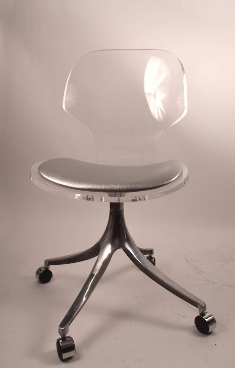 Ensemble impressionnant et élégant de quatre chaises de salle à manger, assise et dossier en Lucite, sièges en cuir argenté, sur des pieds évasés en chrome, sur des pieds originaux à roulettes. Fabriqué par Hill Manufacturing Company - difficile de