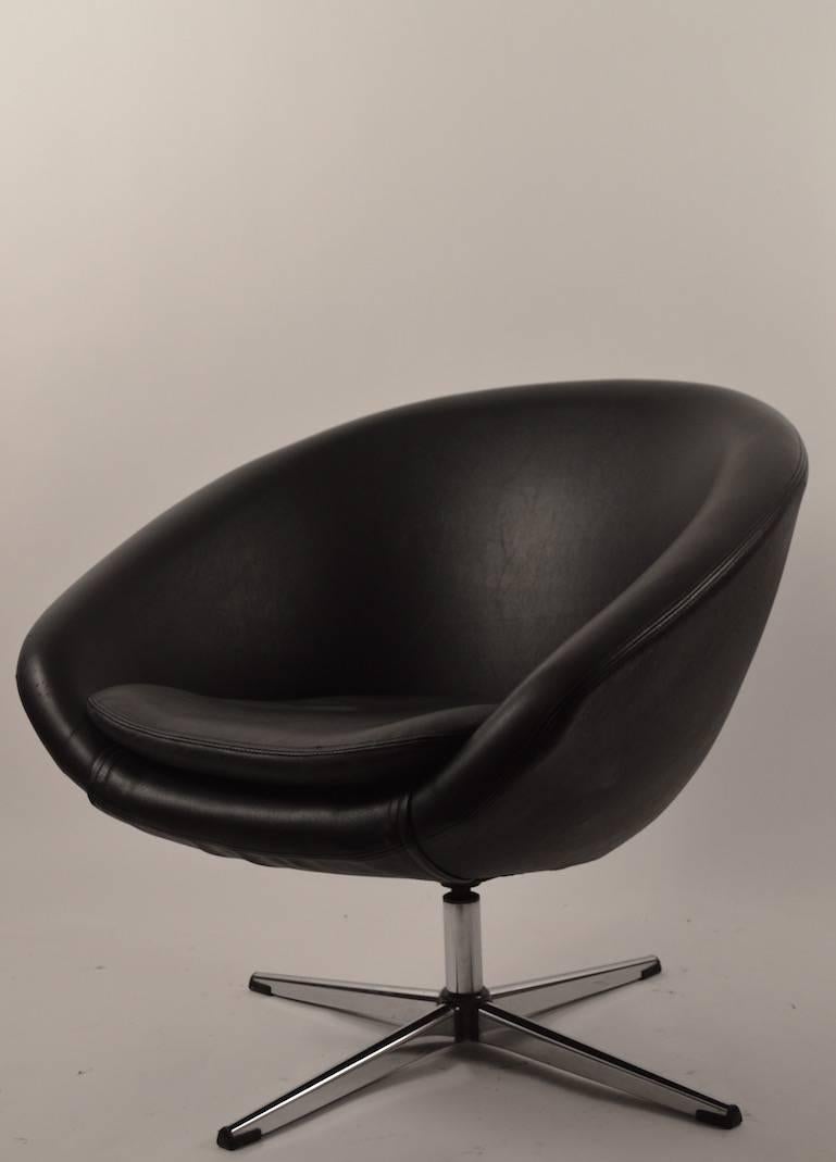 Black vinyl upholstery, chrome four star base, swivel pod chair by 