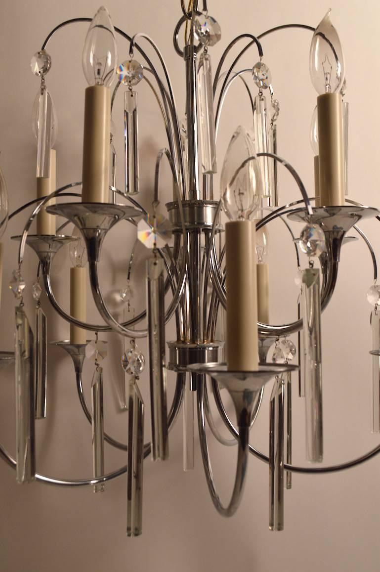 Two tiers of candle up-lights and bright chrome frame with crystal prism drops. Working, clean, original condition and ready to install. Height in listing does not include chain and total drop including chain approximately 39