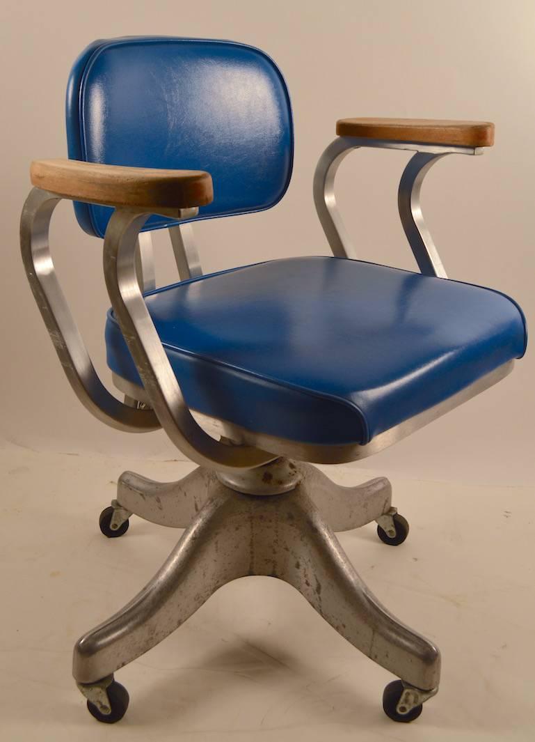 Machine Age desk chair manufactured by Shaw Walker. This chair has several adjustments including a tension adjustment to the backrest, tilting backrest and seat height adjustment. The aluminum frame supports vinyl seat and back cushions and solid