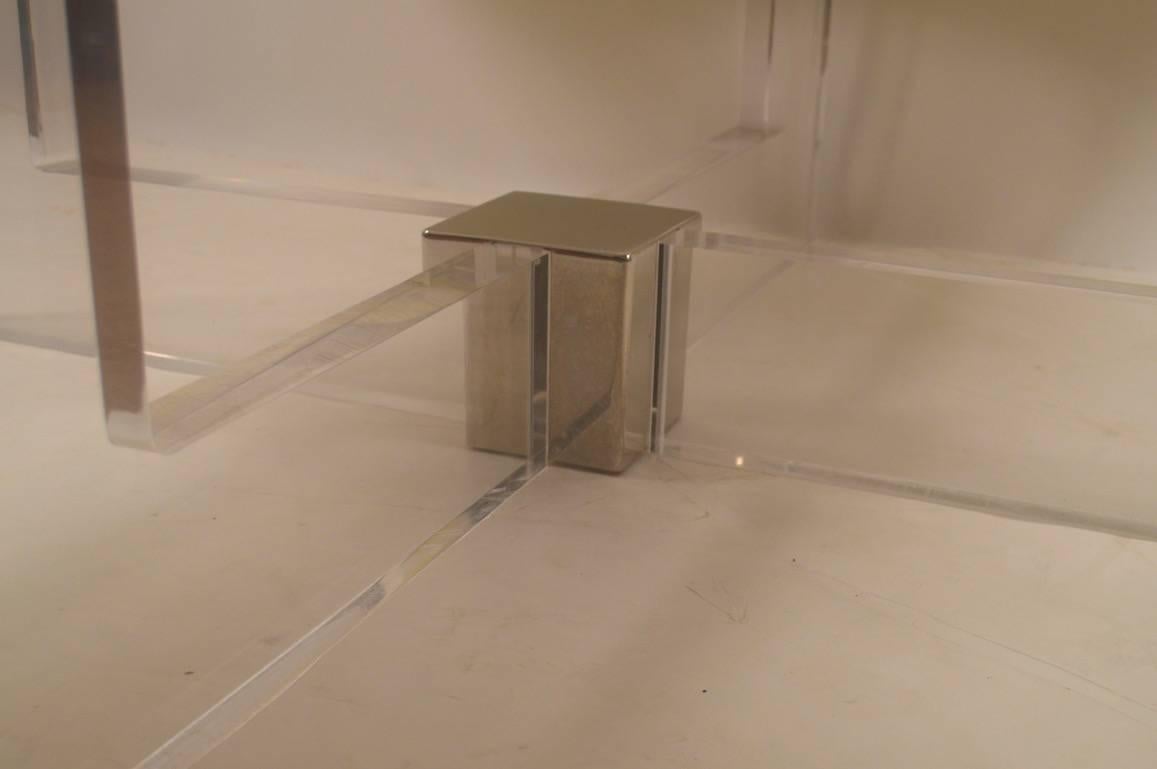 Thick Lucite base supports the steel and brass frame top, into which smoked glass inserts. Measures: Top 