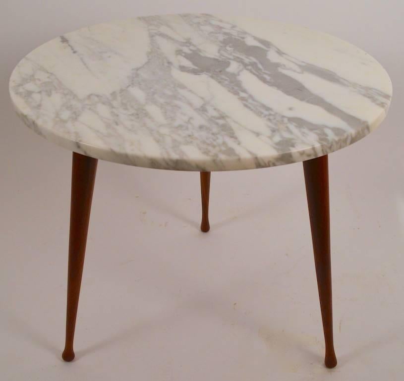 Diminutive round marble-top table on three solid wood legs. Classic and sophisticated Mid-Century design.