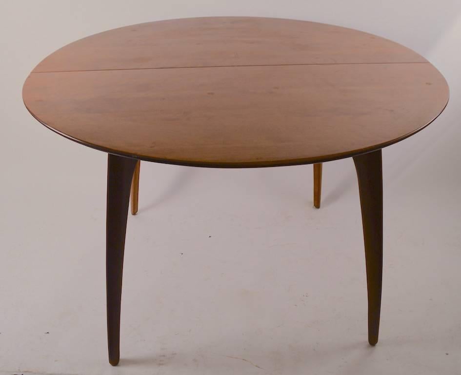 Round Conant ball dining table designed by Russel Wright. This table comes with two large (12