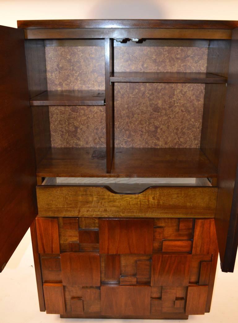 Nice example of the Mosaic line from Lane Furniture company. Raised block front Brutalist style and period. The dresser, armoire, has two doors which open to reveal a lower drawer and open shelved storage. 
 The bottom has three big, deep drawers,