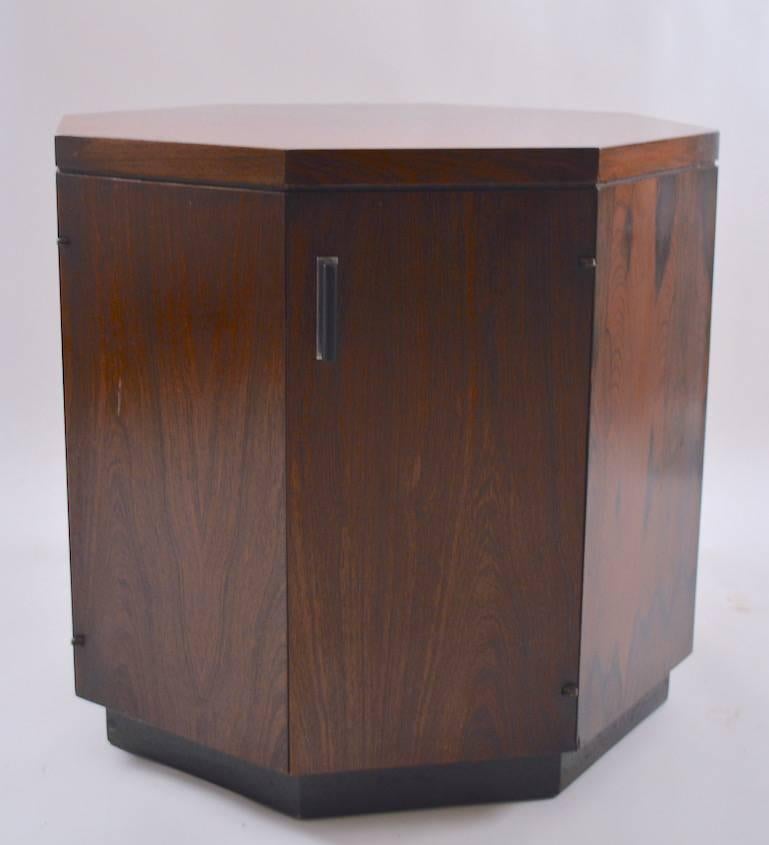 Nice pair of octagonal stands in rosewood in the style of Harvey Probber. Both are in good original condition, one has a scratch on the top, as shown. Each cabinet opens to reveal an adjustable shelf. Suitable for use as end tables, nightstands,