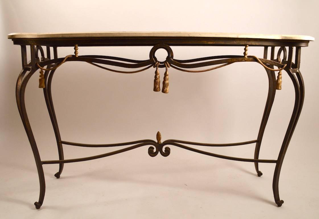 Decorative iron and tessellated stone console table attributed to Maitland-Smith. Faux rope tassels hang from the iron frame which supports the segmented 