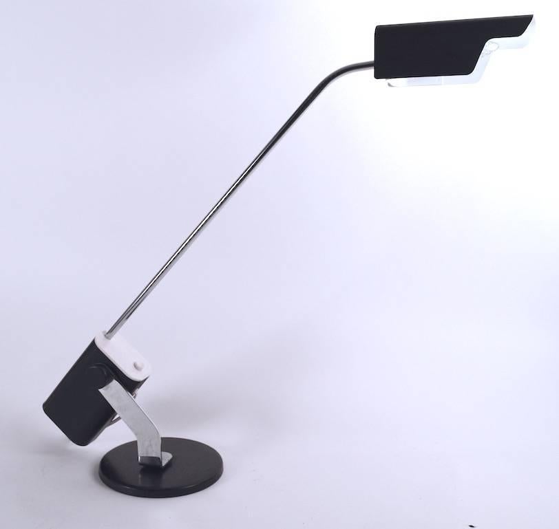 Interesting modernist desk, task, reading lamp. This example is adjustable in height, with a bright chrome arm mounted on a black meta base (Diameter 7