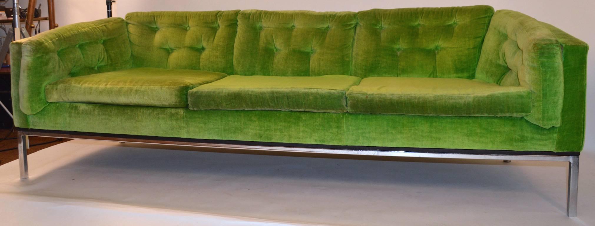 Even arm sofa on squared chrome legs. The fabric shows significant wear, as shown. Arm height 23