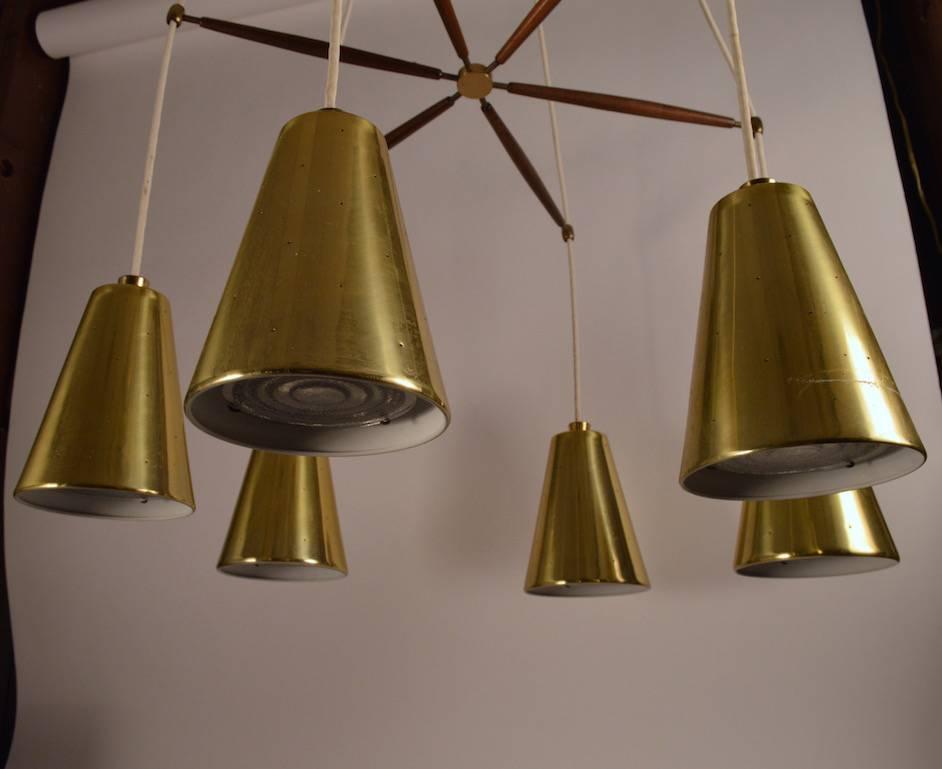 Six cone form shades hang from a centre spoke form structural element. Each shade has its original concentric ring glass diffuser in place. Chandelier is in clean, original working condition. One anodized aluminium shade shows a slight surface