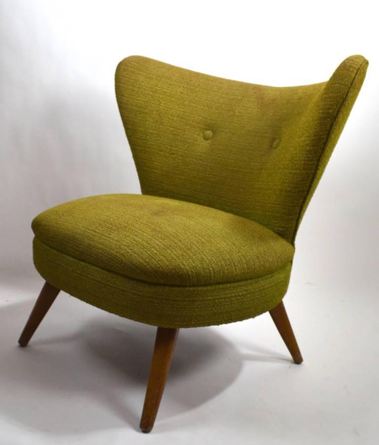 Stylish chair frame of dramatic form, by Heywood Wakefield. This example will need to be reupholstered, as the fabric shows major wear and stains.