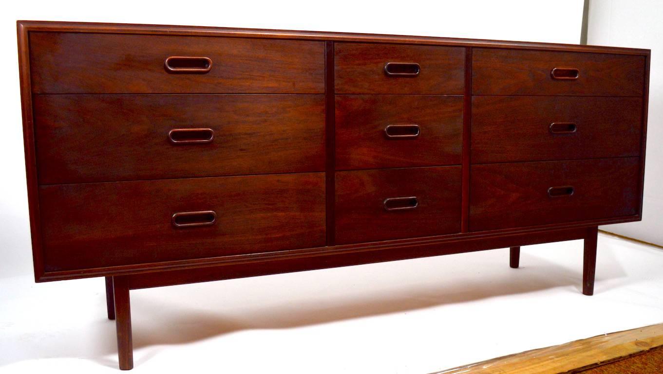 Nice long and low nine-drawer dresser of walnut construction. We believe this chest is American made, in the Danish style. Nine drawers provide ample storage space for garments etc. 
 Finish shows some variation, notably on top, as shown, normal