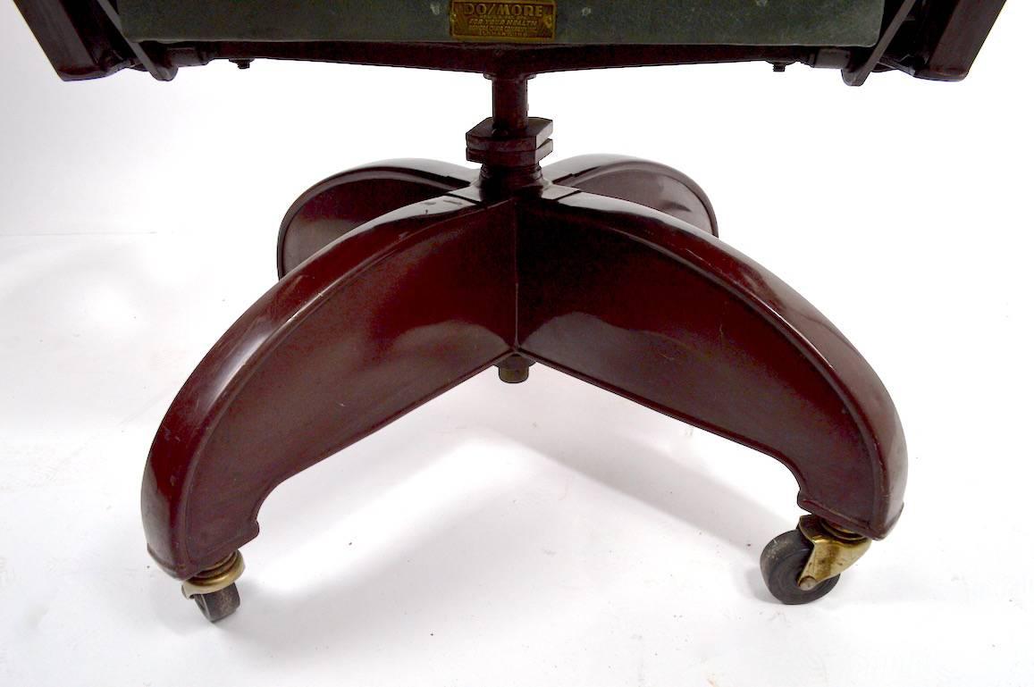 Probably the Cadillac of Do Mor chairs, this example is executed in the Machine Age, Art Deco style, with oversized padded armrests, propellor style base, and upholstered seat and backrest. The chair is in very good original condition, it is in