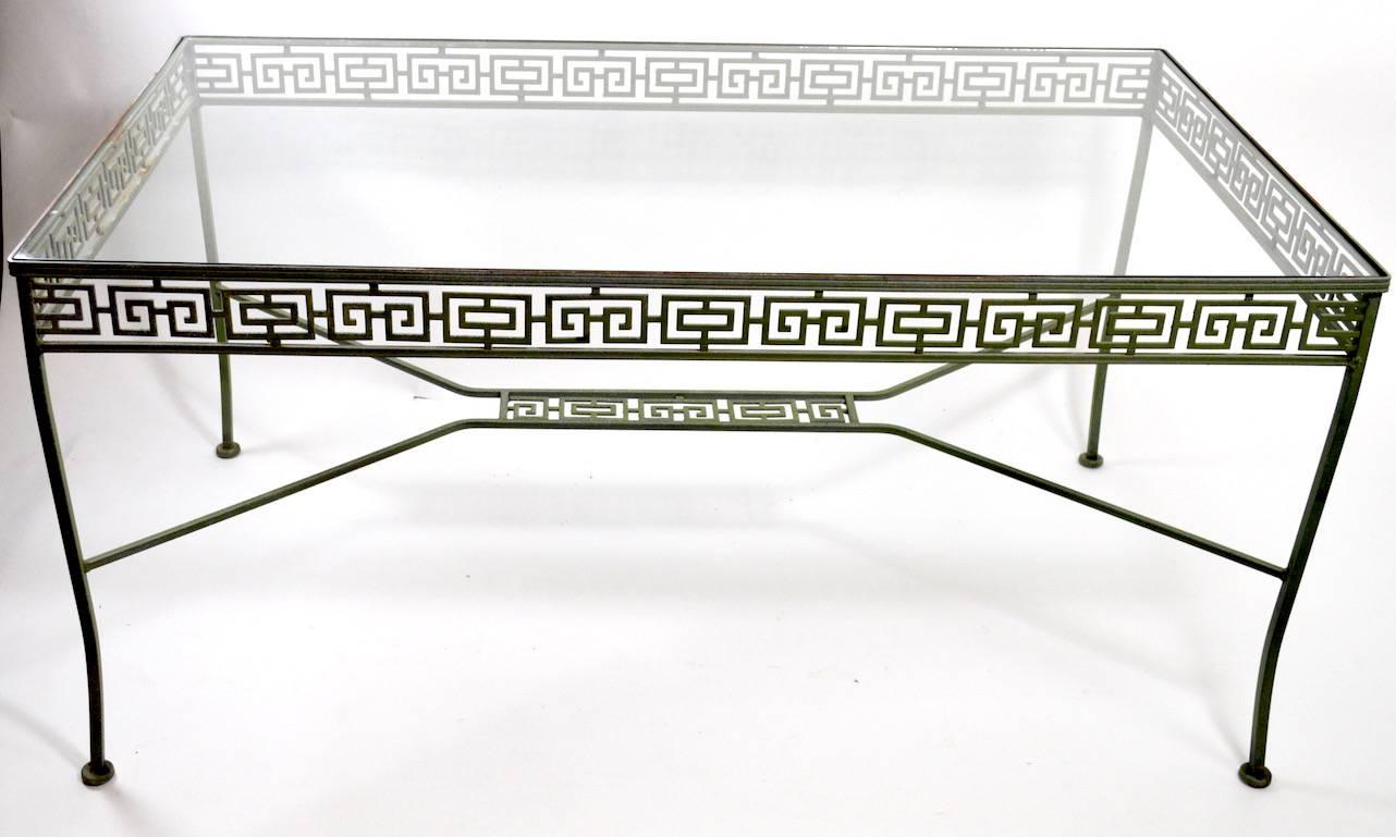 Wonderful Greek key motif wrought iron patio set, set comprised of six chairs, and large glass top table. Original faux Verdis Gris finish, ready to use condition.
Measures: Chairs 33