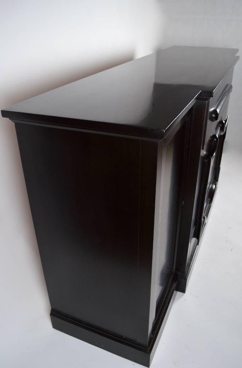 Classic Art Deco Hollywood Regency style ebonized finish fall front desk, server. The sides are swing open doors, which reveal shelved storage. The top 