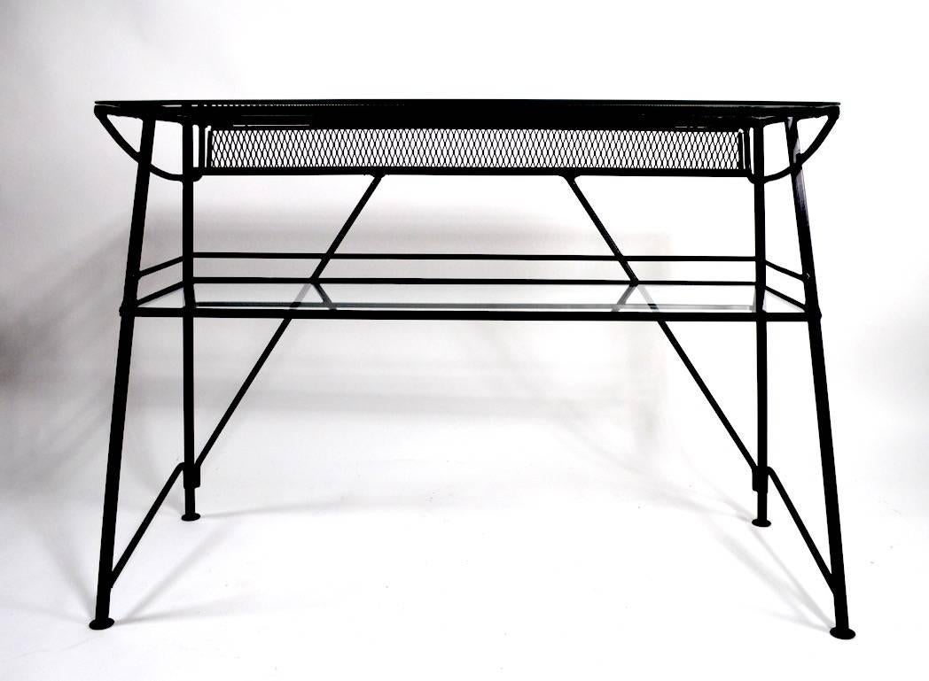 Two tier glass shelves, iron base with metal mesh bottle tray. This unusual and rare bar has been professionally powder coated black making an already nice item truly a gem. Suitable for indoor and or outdoor use, chic architectural design, top