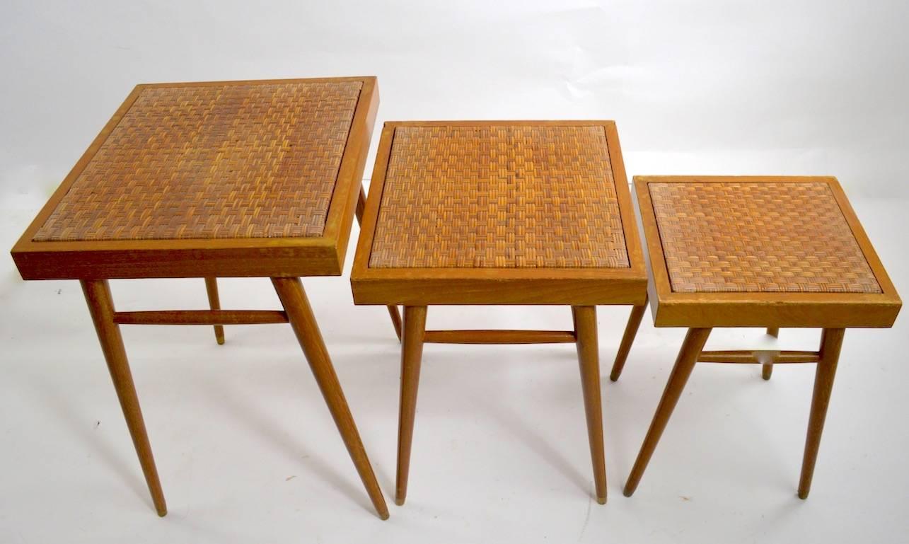 Unusual to find nesting table sets in pairs, two sets of three each tables. These tables are graduated in size, dimensions in listing are the largest of the three, they are cerused finished wood frames with grass mat weave tops. Both sets show minor