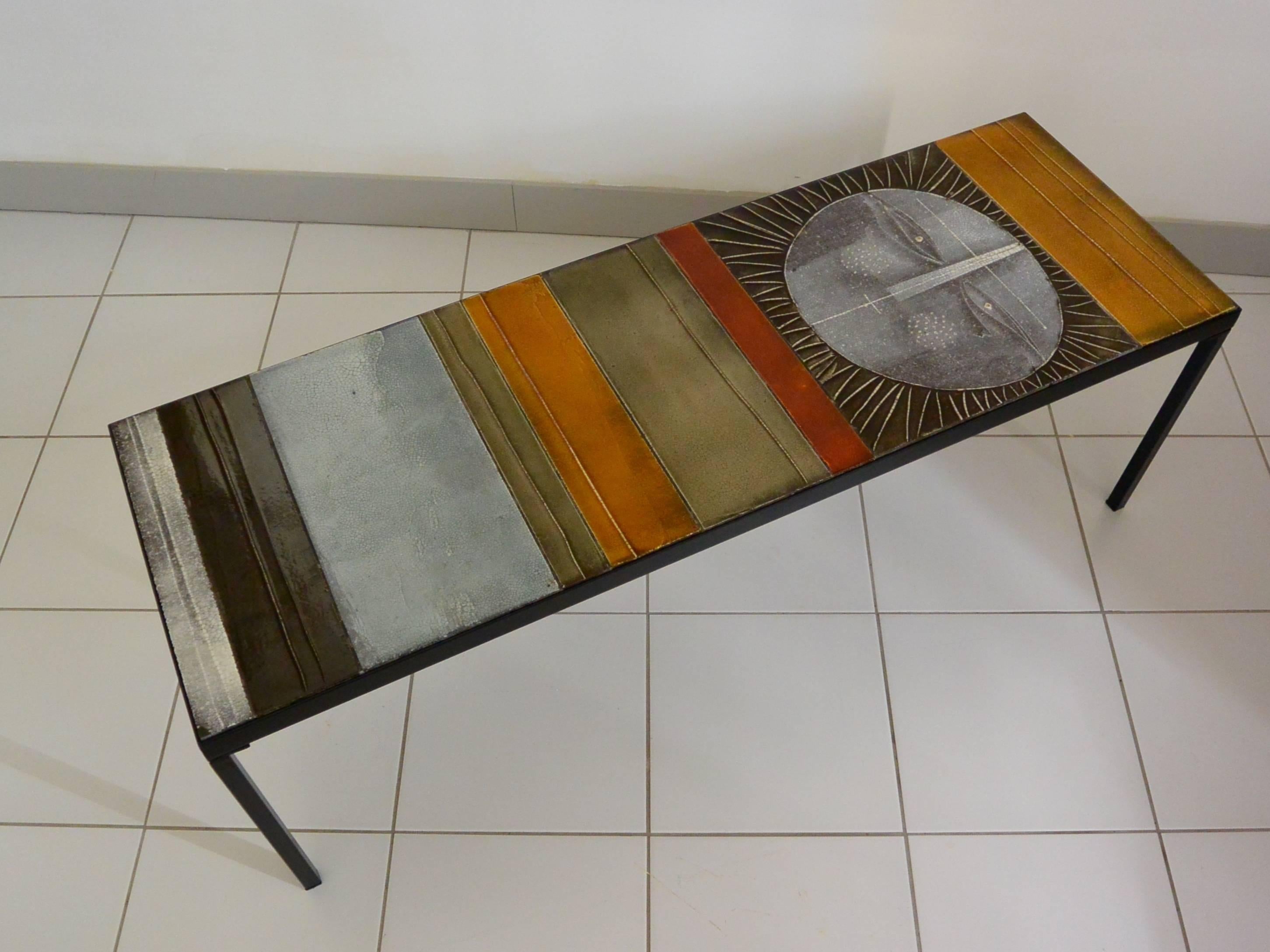 Rare and iconic ceramic coffee table by Roger Capron.
Polychrome glazed lava tiles, decorated with a stylized Sun face.
Manufactured, circa 1960.
Metal, ceramic and wood.