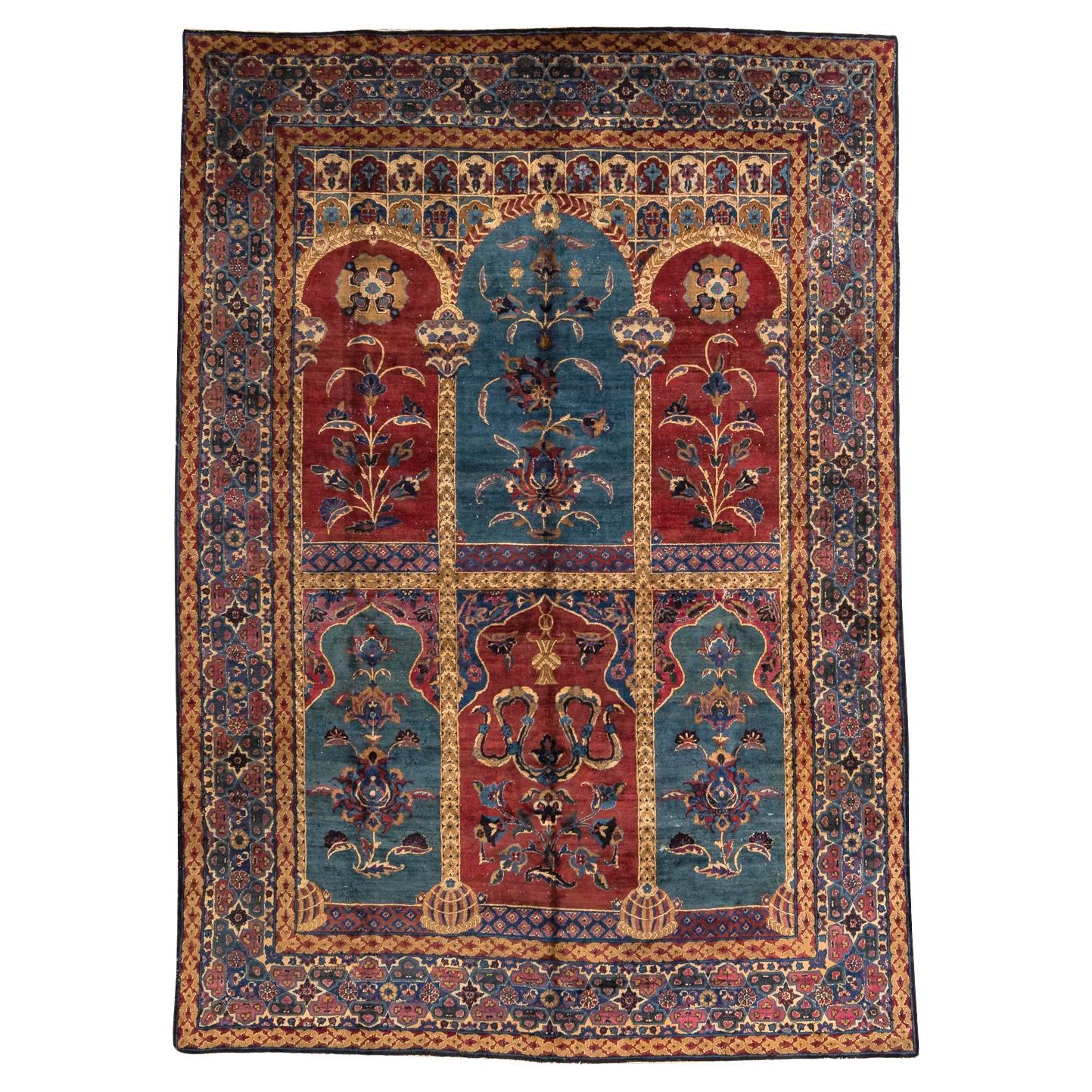 Kerman – South of Persia

This rare and unique rug exhibits a design influenced by Indian aesthetics. The carpet comprises six arches between bordeaux and dark cyan colours, supported by richly crafted columns. Each arch is filled with large-scale