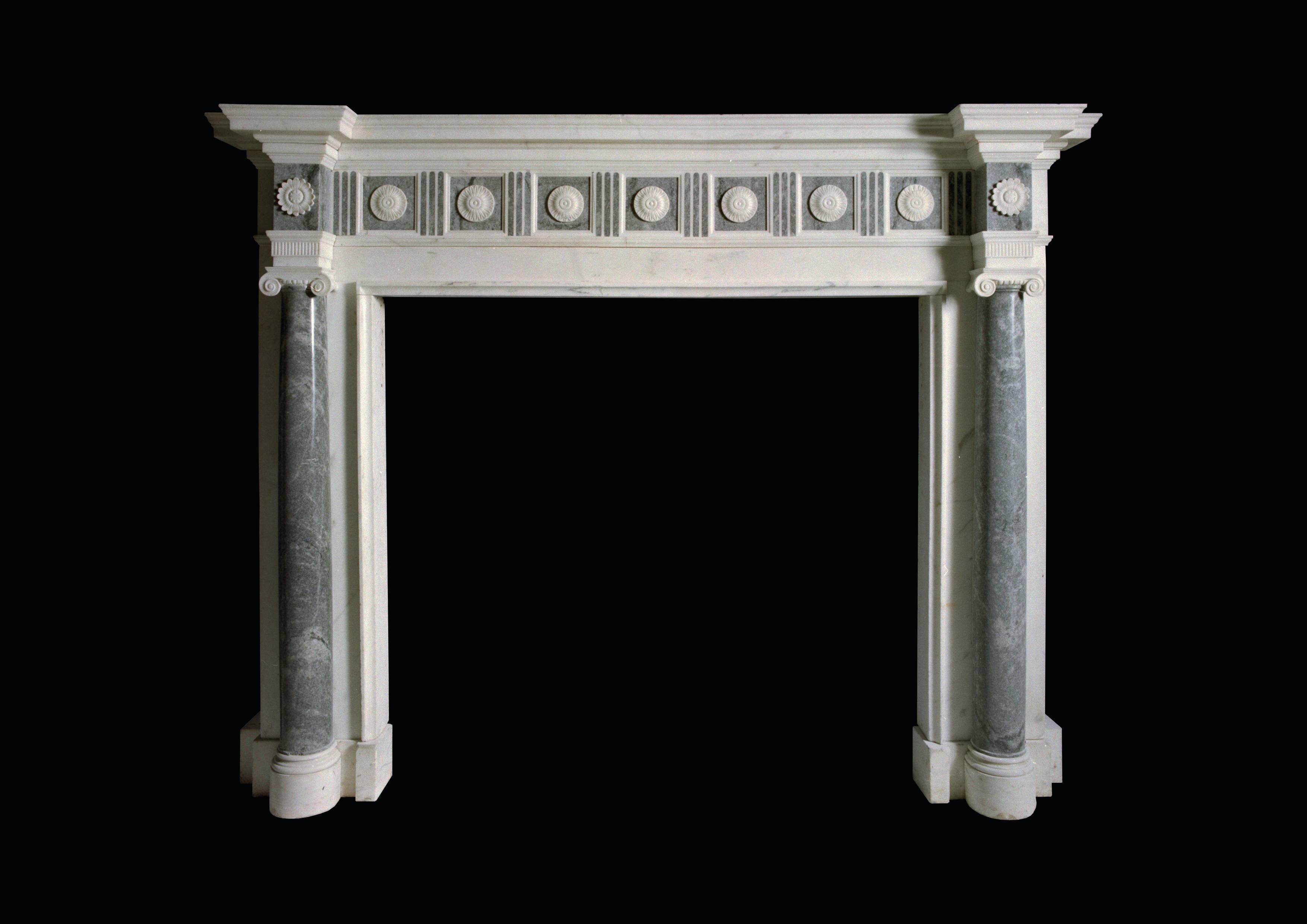 Reproduction of an important late 18th century English chimneypiece in statuary marble with engaged three quarter columns in Bardiglio Imperiale marble. The running frieze and corner blocks of the same material, the former overlaid with finely