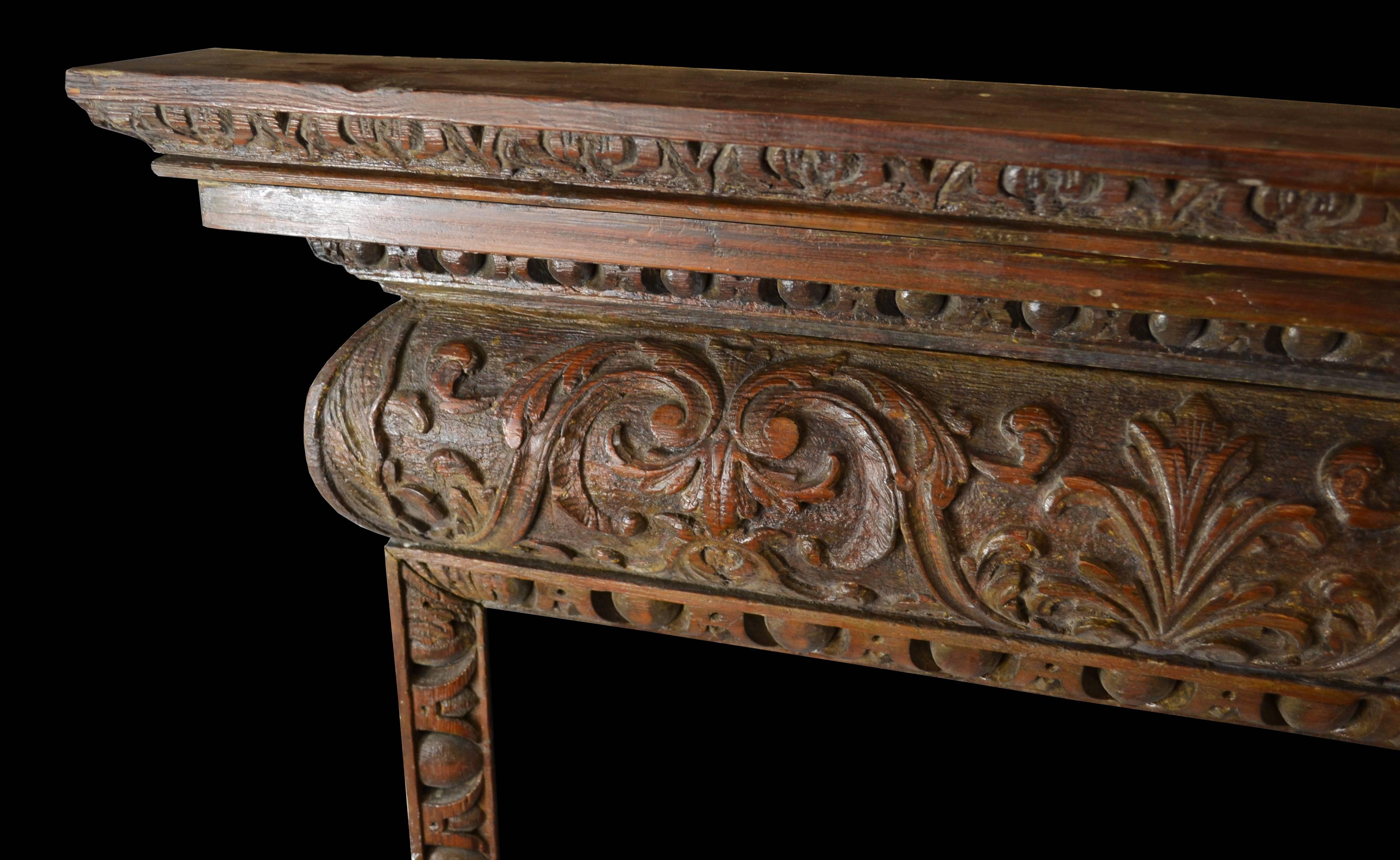 An 18th century carved oak mantel featuring highly detailed egg and dart molding along the frame and under the shelf and a running frieze carved with acanthus. 

Opening dimensions: 41