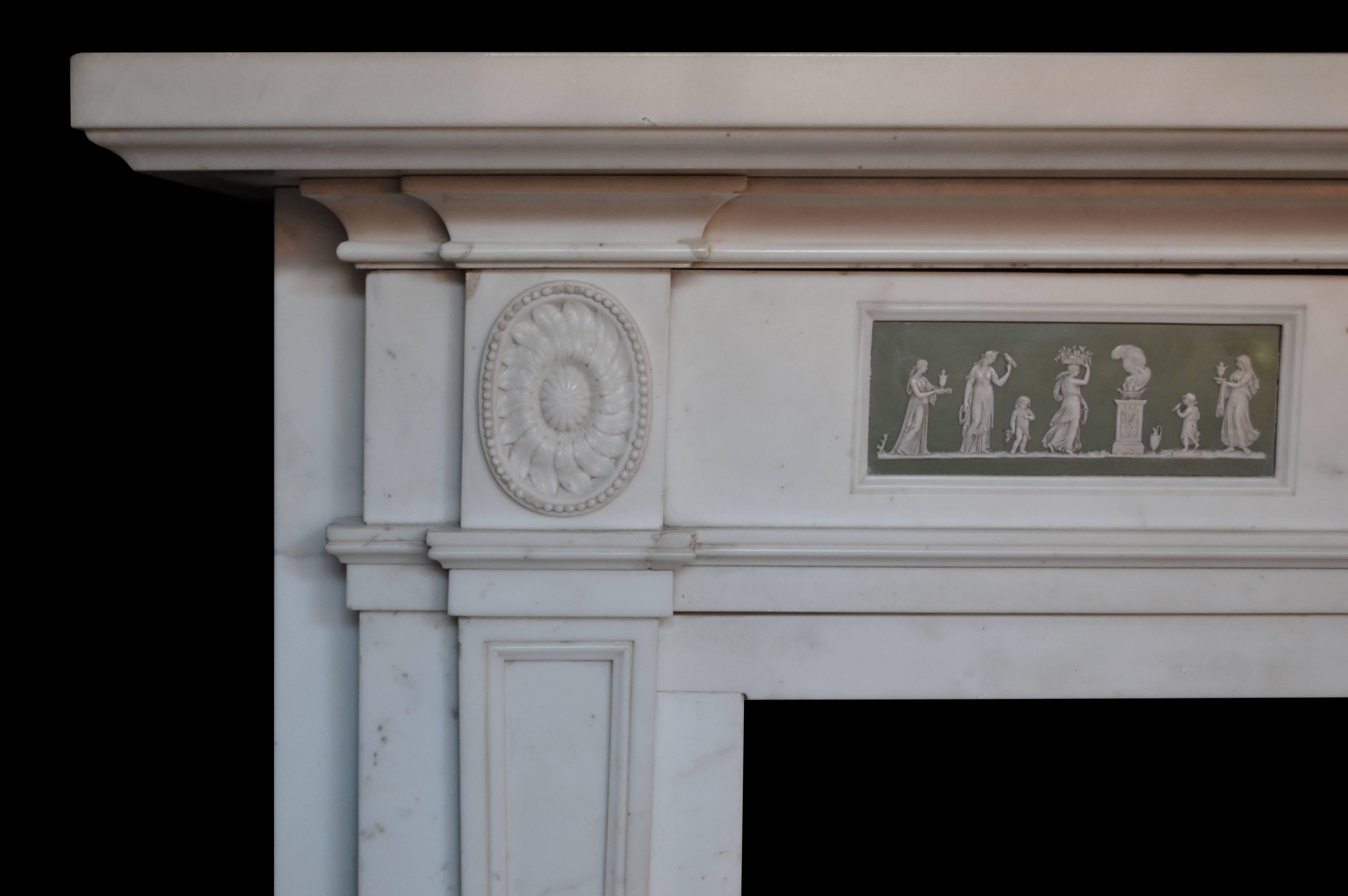 A generously proportioned mantel carved in statuary marble with two medallions and a center tablet with carvered urn. The mantel frieze features two porcelain wedgewood panel inlays. 

Opening dimensions: 47 1/2