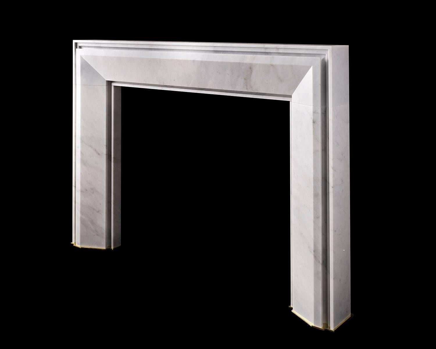 The Monroe designed by Pembroke & Ives for Chesney's. This tapering frame design springs out from a deep circular undercut detail creating a strong visual appearance. Hand carved in Carrara Marble with brass base plates.  

Opening dimensions:46