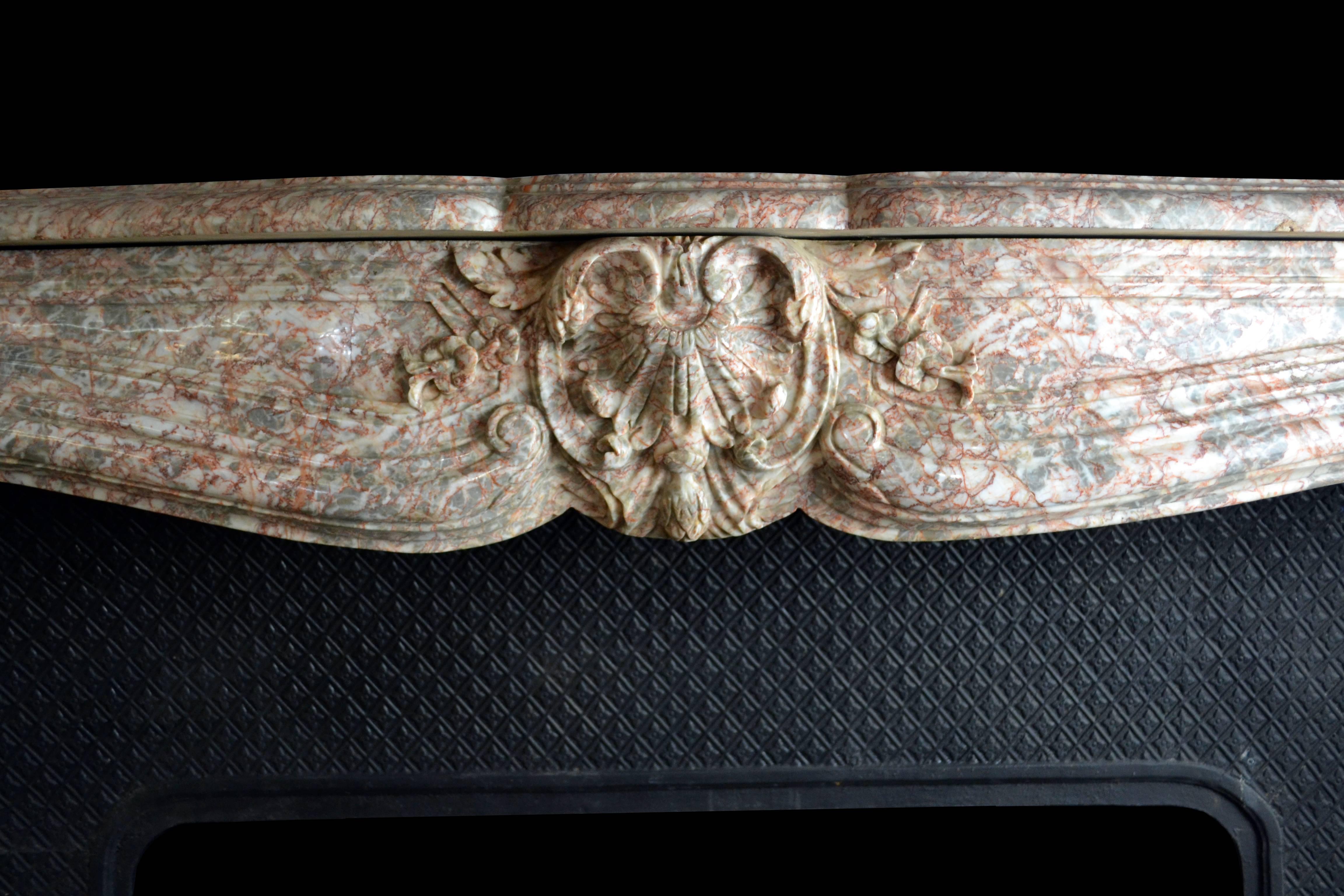 A Rouge marble Louis XV French mantel with a central cartouche and cast iron insert.

Mantel opening dimensions: 47 1/4