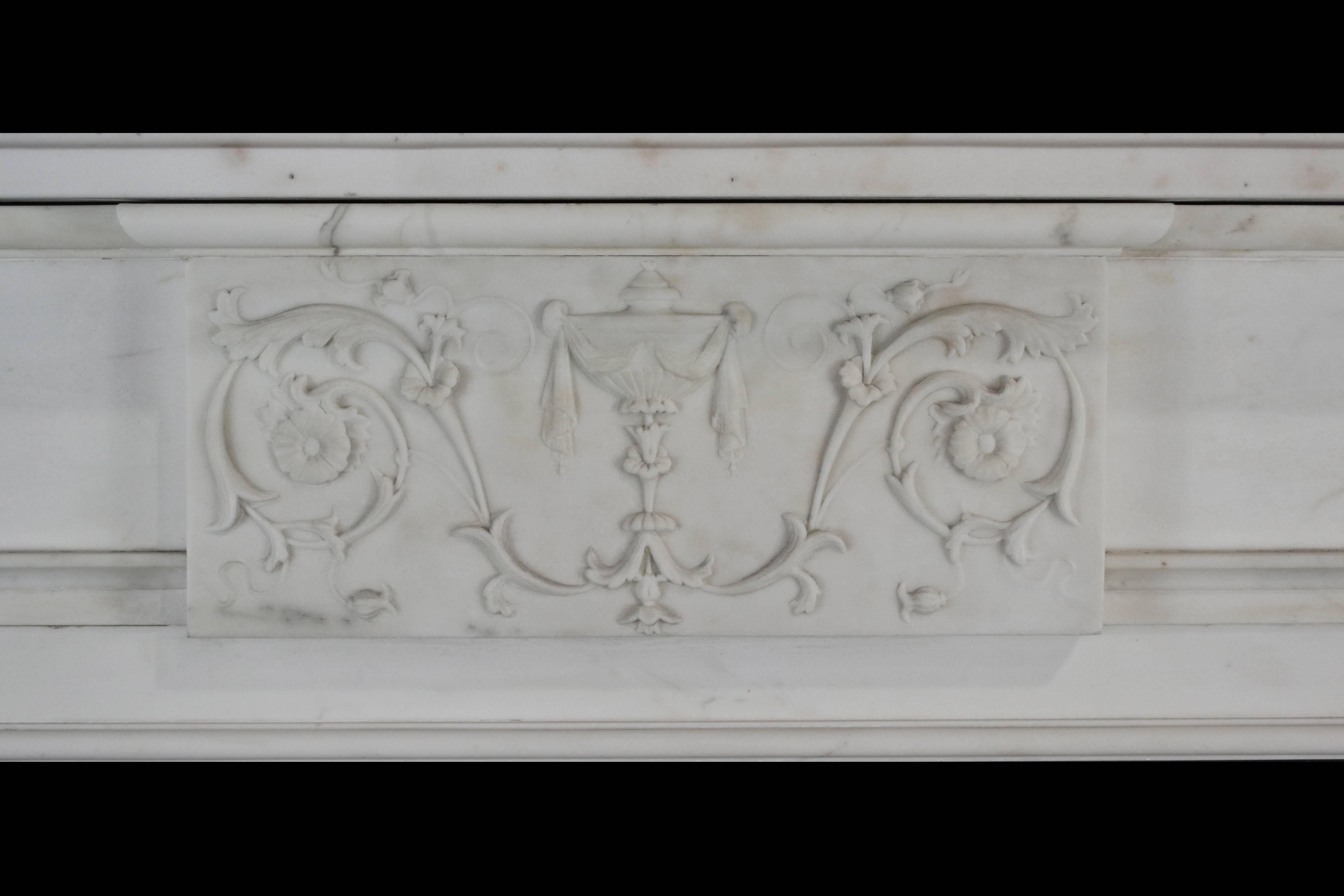 An early 19th century English mantelpiece of restrained and elegant form, incorporating later elements and repairs, in Italian statuary marble with tapering fluted pilasters headed by corner blocks carved with anthemion, a neoclassical centre tablet