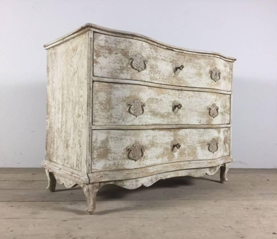 A French serpentine front chest of drawers with a shaped top and old paint patina from the late Louis XV period. This chest has retained its original hardware with working locks and keys.