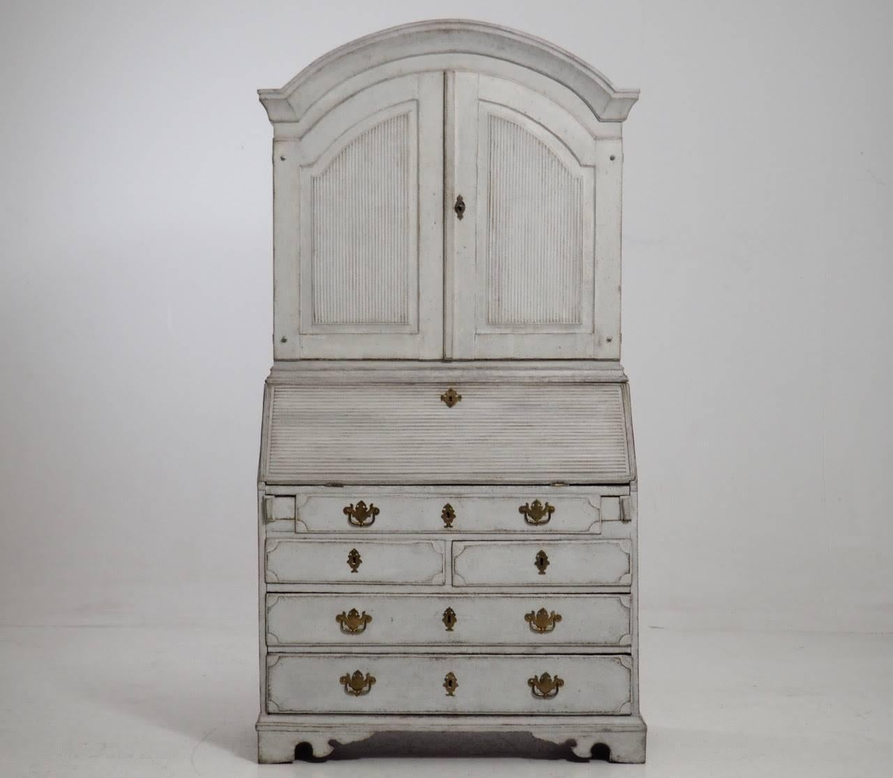 This is an exquisite Swedish Gustavian period painted secretary with library and original brass hardware and locks, circa 1780. The upper section has three shelves, the top shaped and slotted for spoons, behind door fronts carved with reeded panels.
