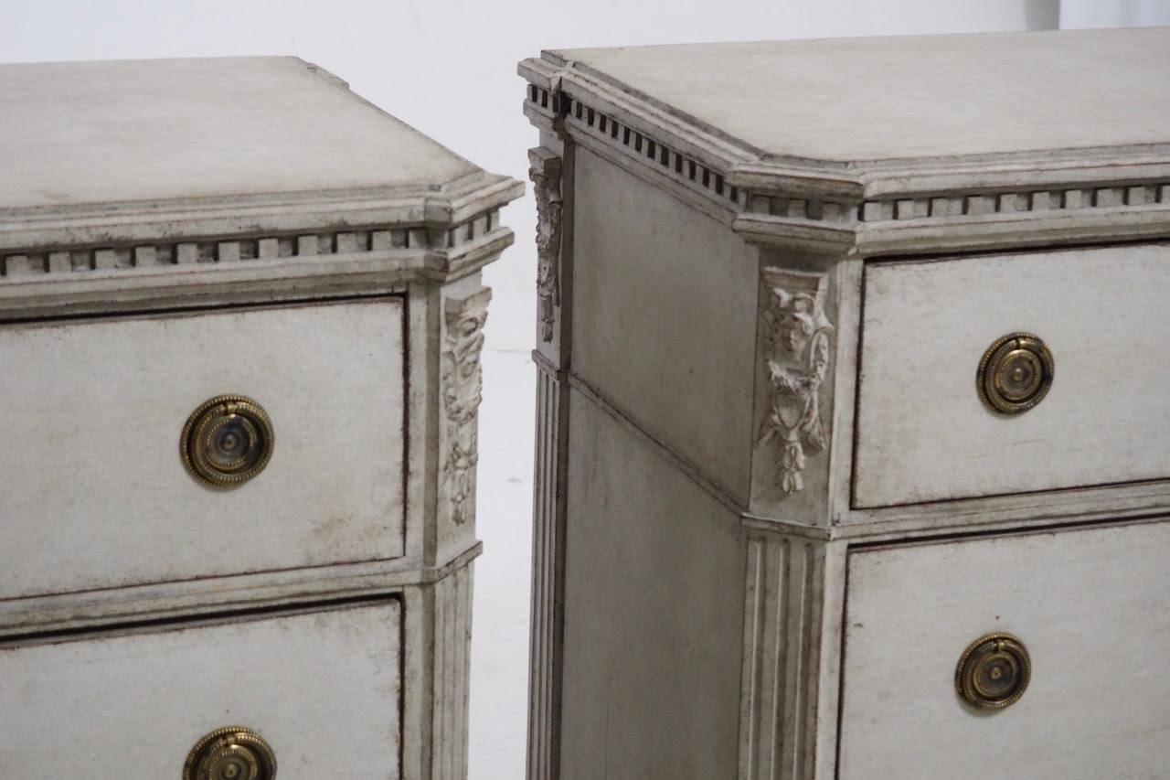 A beautiful neoclasical pair of Swedish painted chests from the late Gustavian period. Each chest has three drawers, brass hardware and original locks and key. The corner posts are canted and fluted with ornate carvings at the top. The top is framed