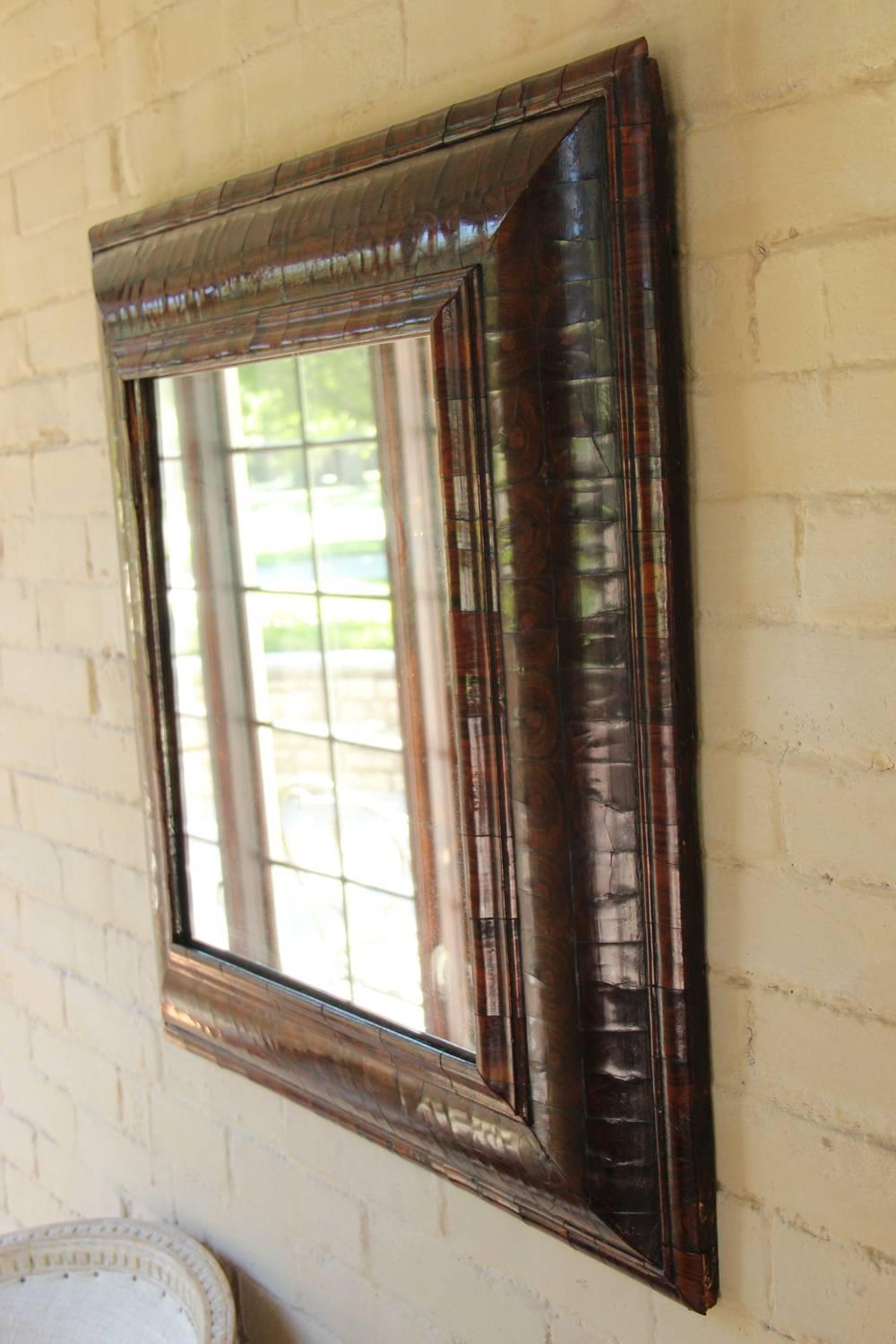 An English mirror with mercury plate from the 18th century of exceptional detail. The frame is made of crosscut and book-matched Brazilian rosewood veneer and has a beautiful French polished finish. The arched top, likely added during the 19th
