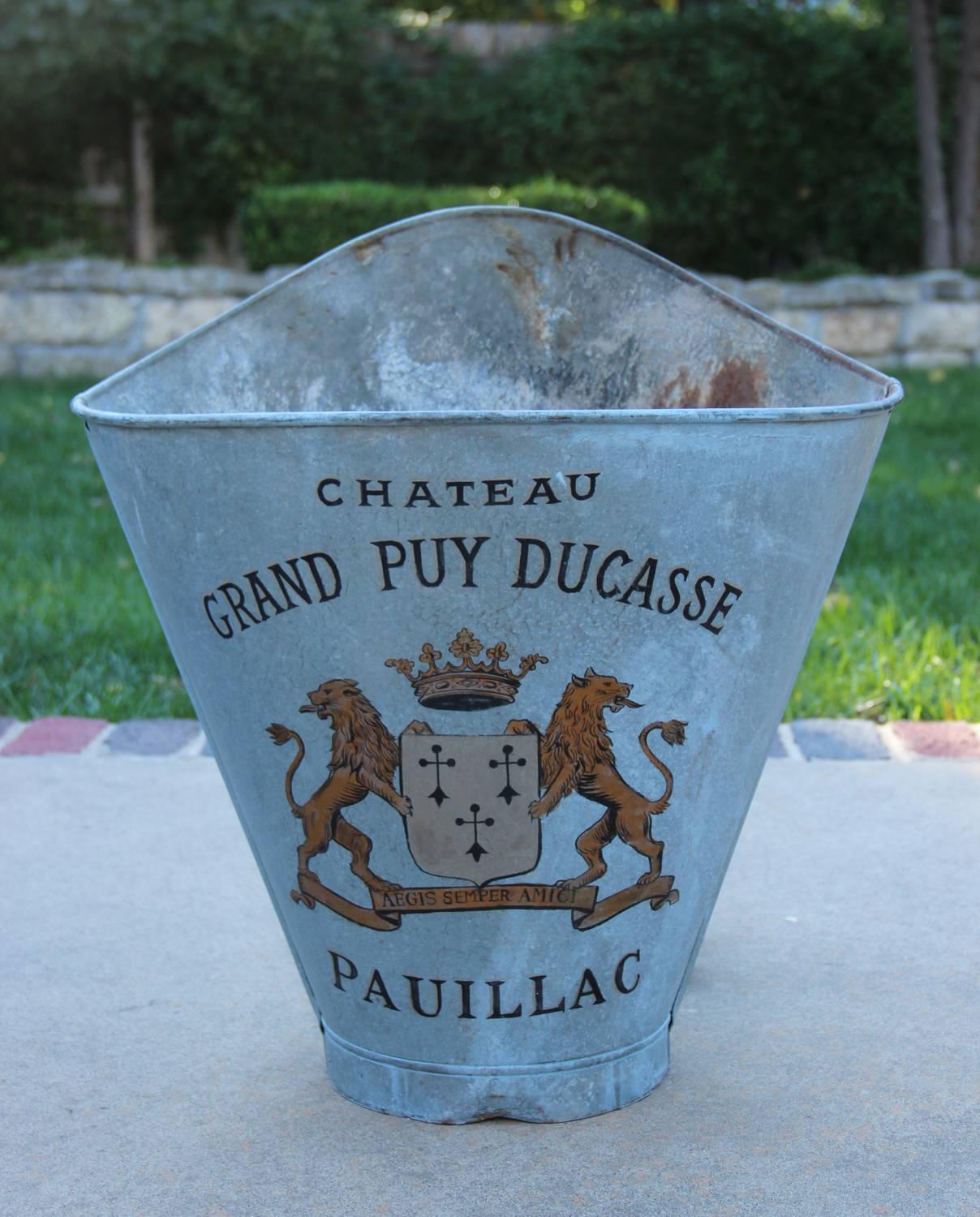 Late 19th century French zinc grape hods with leather back straps. These beautiful French grape hods were once used to collect grapes. This hod features the famous Château Grand-Puy-Ducasse vineyard cote of arms from the Bordeaux region of