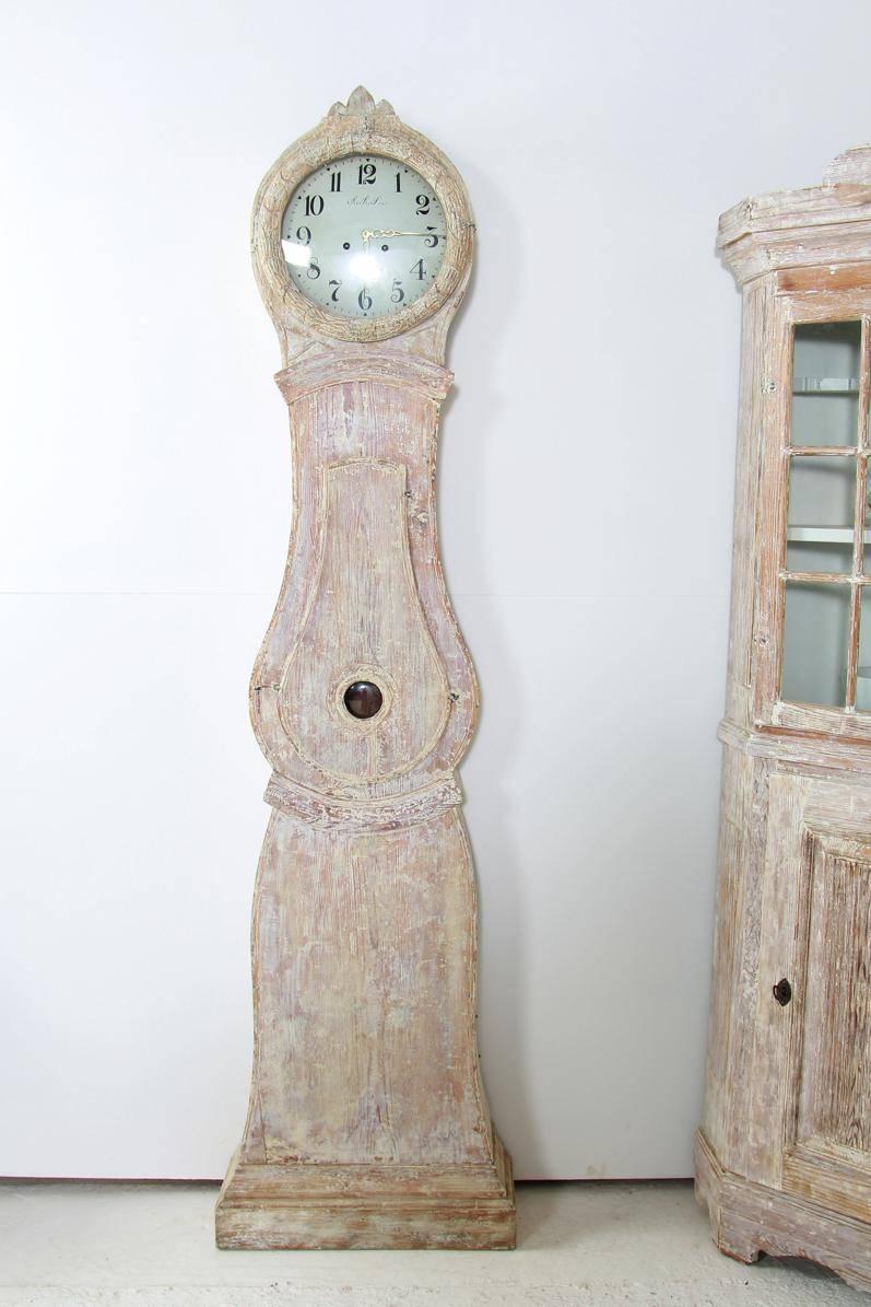 There is a video of the clock running with chime available upon request.  A Swedish tall case clock from the Gustavian period in the Classic Mora form.  Circa 1810.  This charming clock has been dry scrapped down to its original creamy white paint