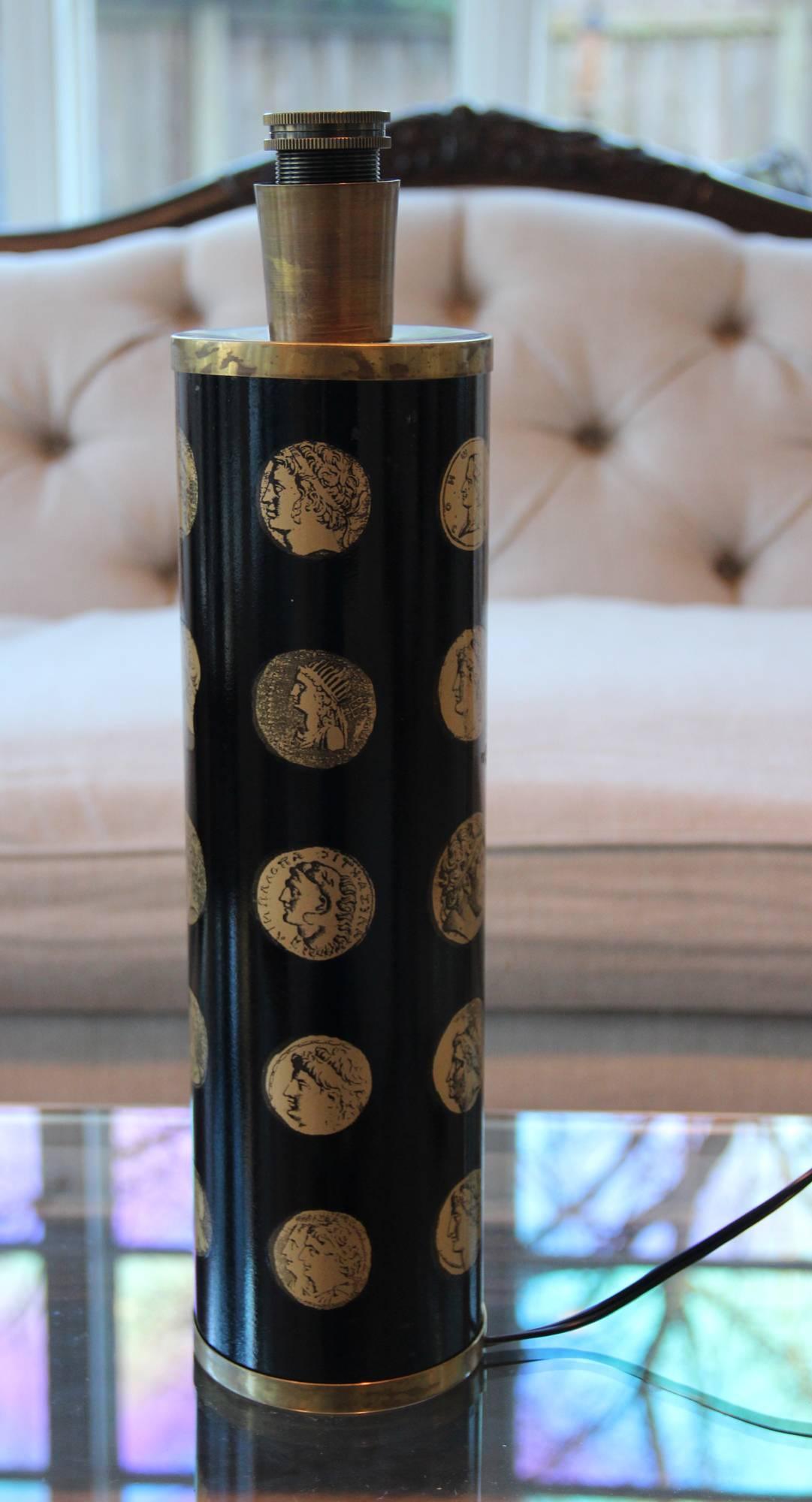 A Piero Fornasetti (1913-1988) 'Cameo' model neoclassical style table lamp from the Mid-Century Modern period, newly wired with a new socket and ready for use in the U.S. This Italian enameled metal table lamp with black base features gold transfer