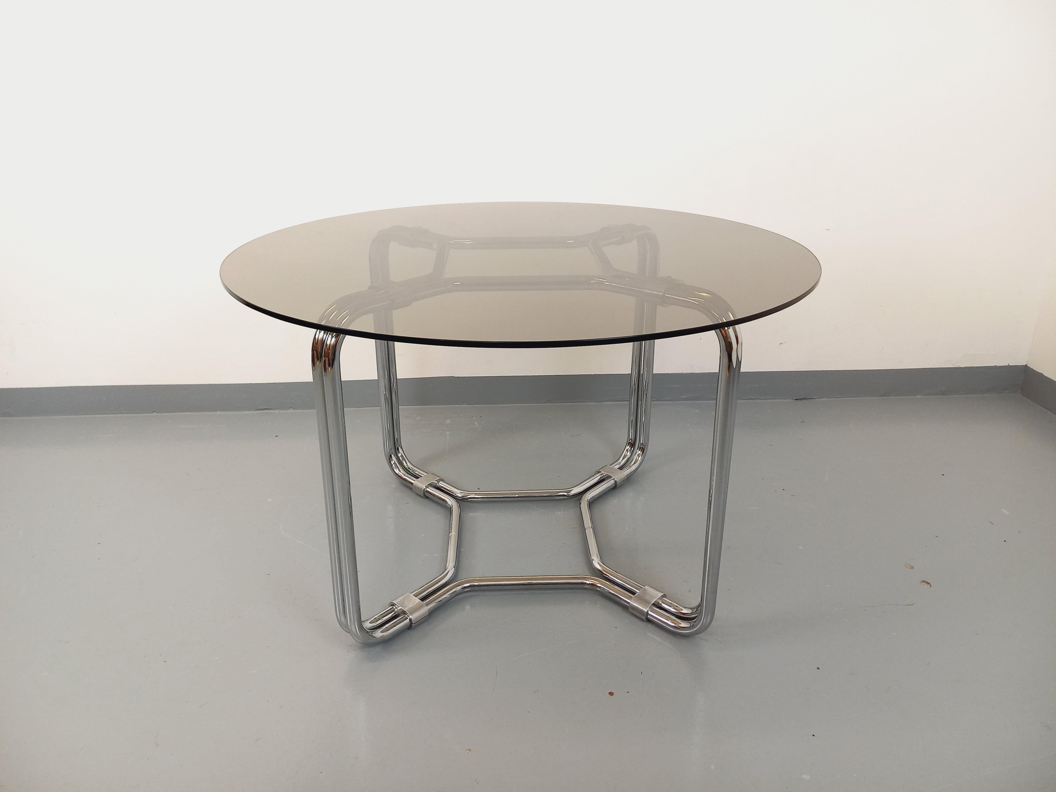 Table ronde à manger vintage des années 70, style Space Age, plateau rond en verre fumé, pied en métal chromé design dans le style de Giotto Stoppino, très bon état général avec quelques rares micro-rayures de surface sur le plateau en verre.
Ref