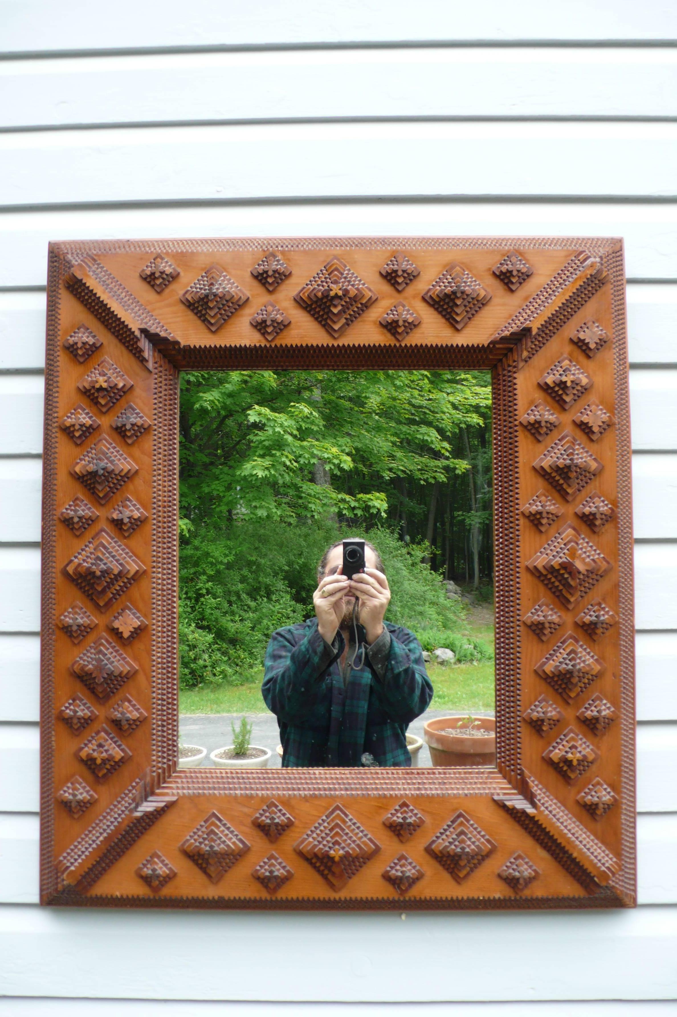 Large Tramp Art mirror. Tramp Art was an art movement found throughout the world where small pieces of wood, primarily from discarded cigar boxes and shipping crates, were whittled into layers of geometric shapes having the outside edges of each