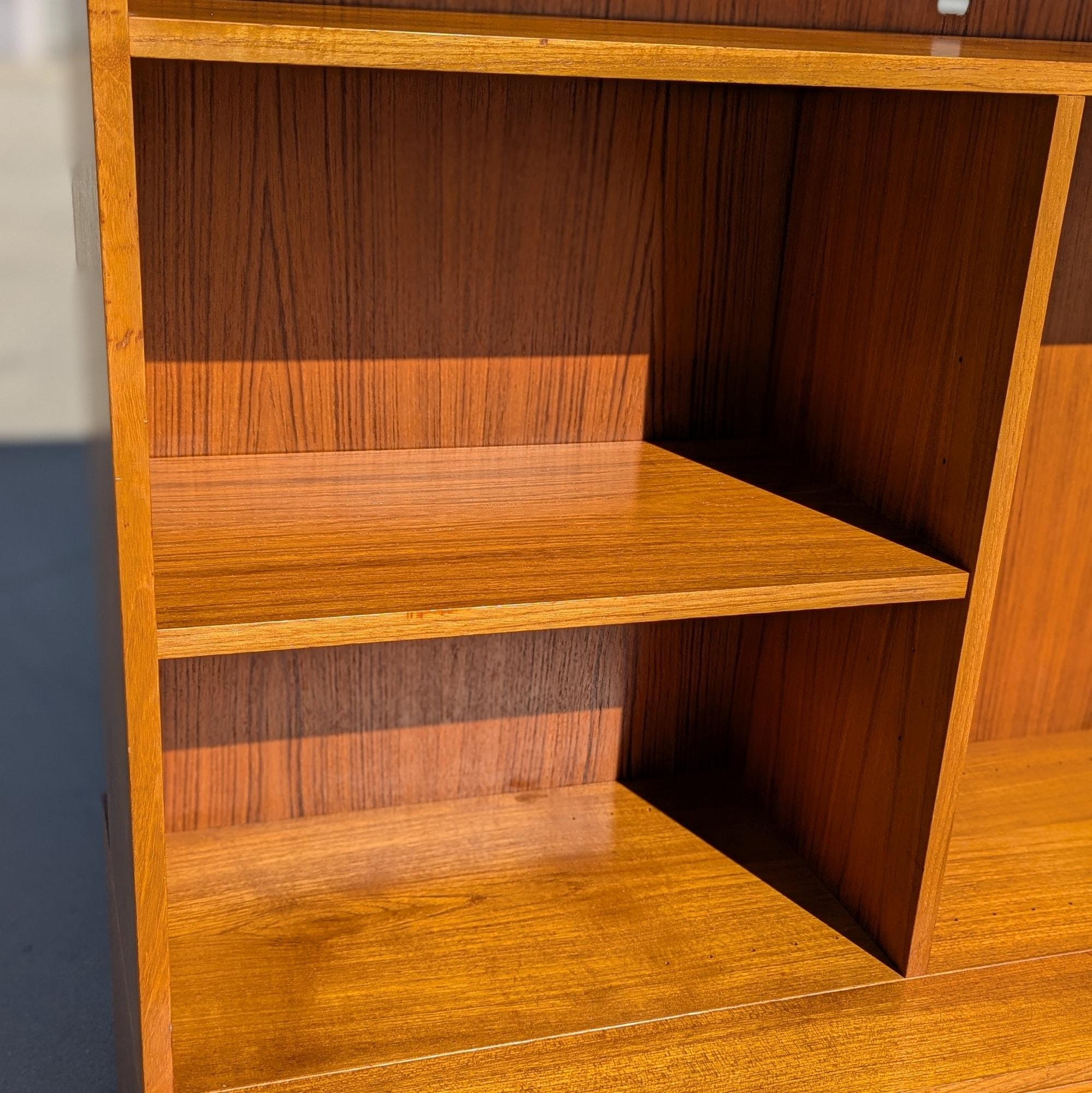 Legno Libreria e mobile a parete in teak, impiallacciatura di teak, finitura calda, Danimarca, 1960 ca. in vendita