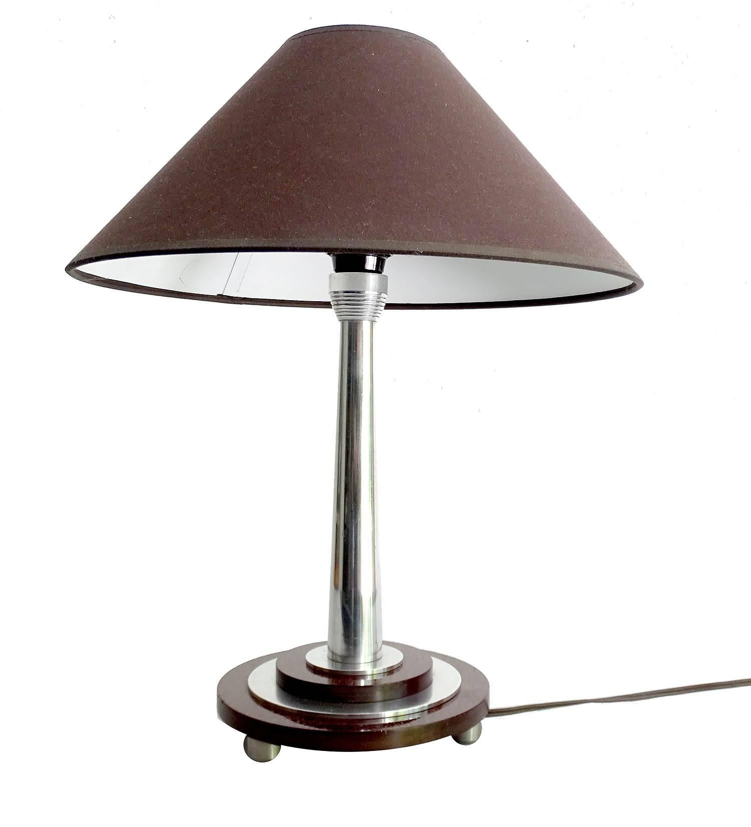 Pair of French Art Deco table lamps, very rare design featuring a polished metal and Bakelite stepped base, dark brown fabric shade.

One standard bulb each. - LED compatible

The Art Deco style name was derived from the Exposition Internationale