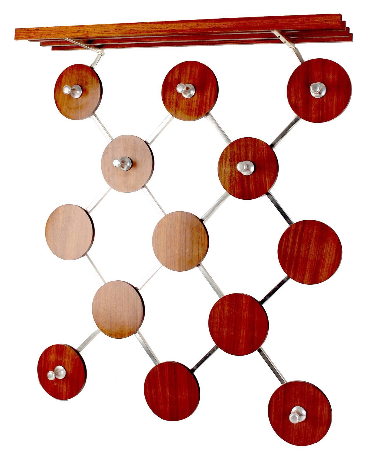 Very large Mid-Century coat rack with an exceptionnal design, It is made of an aluminium structure with 13 round wooden cut-out veneered with Rosewood , seven aluminum hooks for clothes and bags (or children coats), it comes with an integrated hat