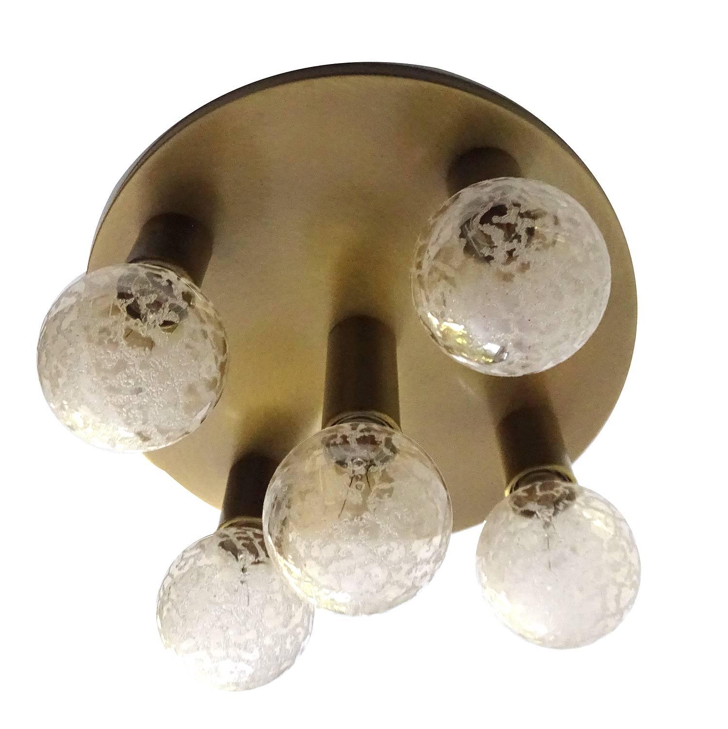 A flush mount light by Kaiser, burnished brass base and bulb fittings
9.06 in.H / 23 cmH
Diameter
14.57 in. (37 cm)
Five standard size bulbs, 60 watts each


The stylish elegance an design suits  mid century to hollywood regency interiors  and