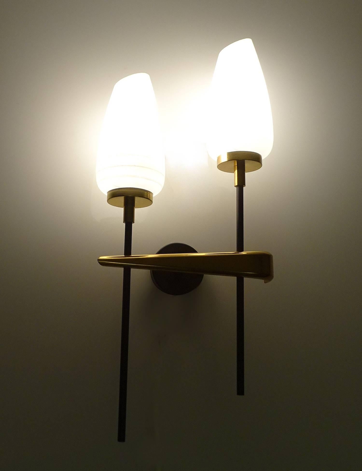 Pair of large French sconces by Maison Arlus from the 1960s, featuring a black enameled structure with with  upright lights (ascending and descending like musical notes). with a swooping heavy bronze headpiece, chamfered opaline glass shades with an