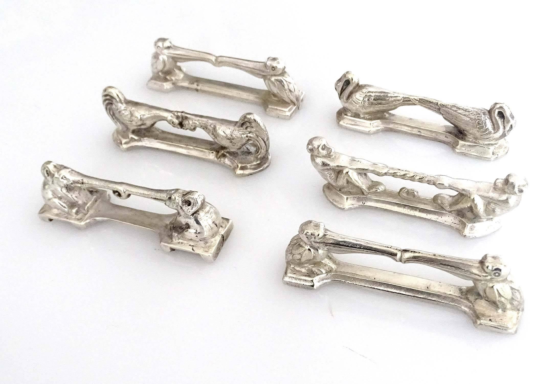 Set of six French Art Deco silver plated knife rests manufactured, circa 1930-1935, silver plated bronze, here with the pelican (two), elephant, monkey chickens and swans.

The Art Deco style name was derived from the Exposition Internationale des