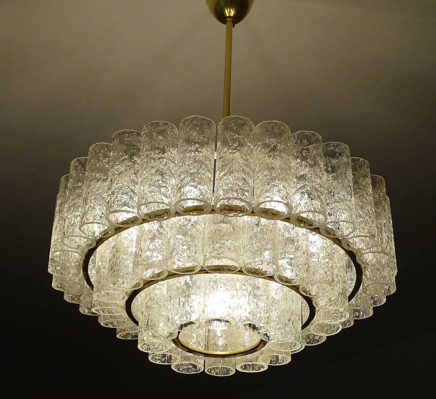 Doria chandelier, three-tier structure with Murano glass tubes, each tier punctuated with a brass ring. This is a variation of the model 4126, which received the prestigious German design excellence award IF (Industrieform) in 1968.
22.83 in H / 58
