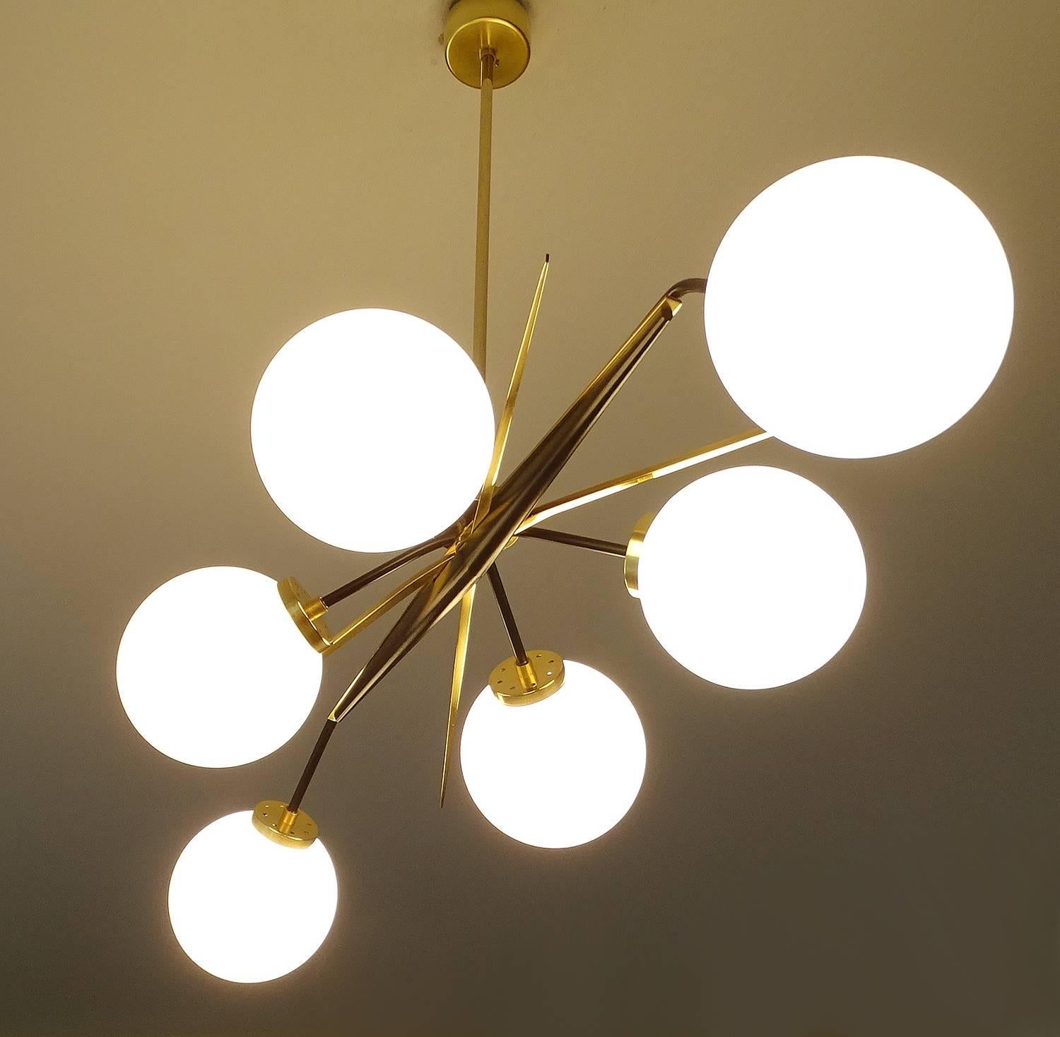 Very sculptural large chandelier by the 1960s French lighting designer Arlus featuring an elongated stylised sunburst design, with six black enameled arms and a brass cross, central beam glass globes on brass fittings

Dimensions
28.35 in. H x