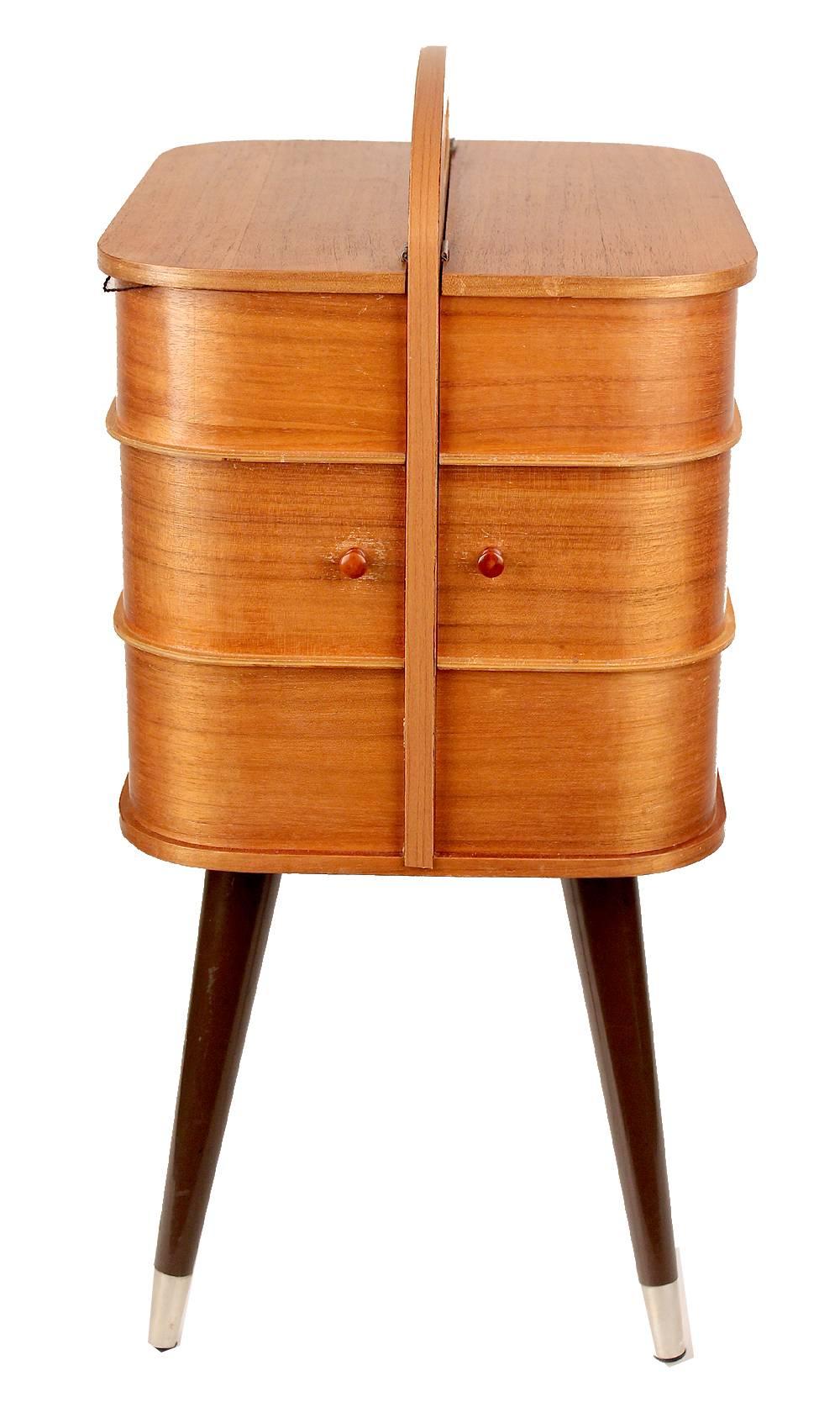 Stunning Danish Mid-Century storage box with integrated handle and revolving drawers, the drawers hide four storage boxes.

The upper section with individual lid is divided in two compartmented sections, can be used for many purposes.

Danish