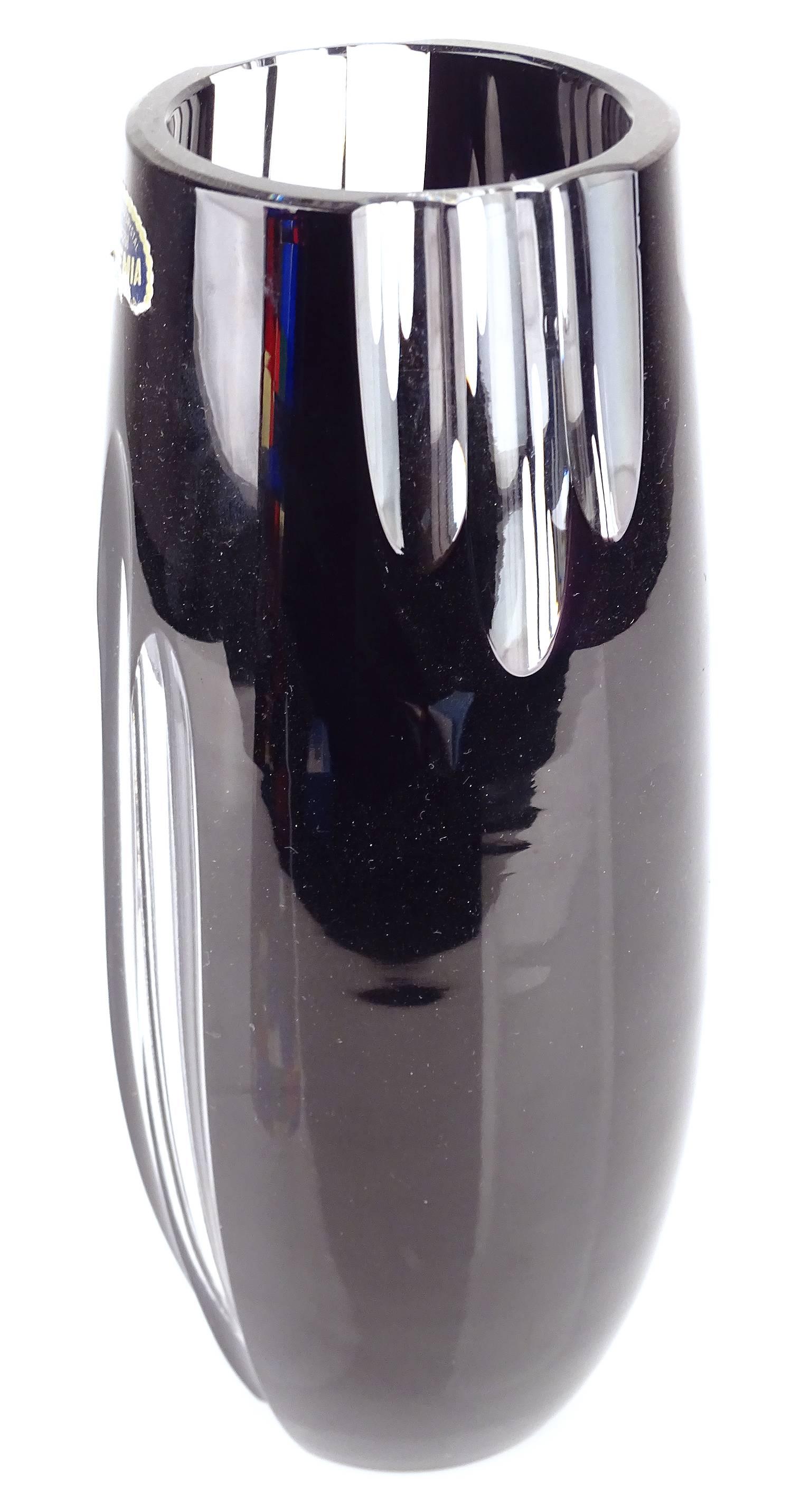Solid Crystal Glass Ebony Glass Vase, manufactured around 1965-70
in Bohemia, fluted shapde with on 4 sides 3 clear scalloped stripes
original label 