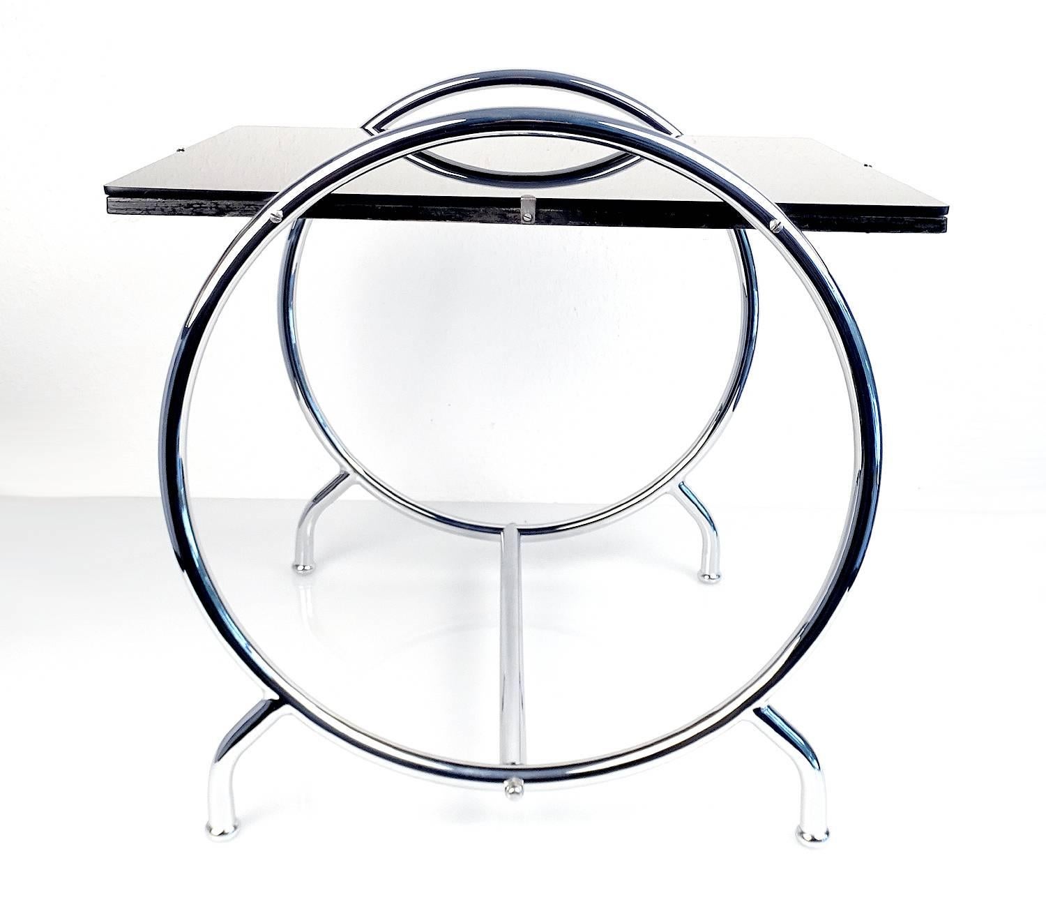 Very elegant Bauhaus Machine Age Era tubular design table circa 1935, very rare round shape, reverse enameled glass on wooden top, rechromed base

The Art Deco style name was derived from the Exposition Internationale des Arts Décoratifs et