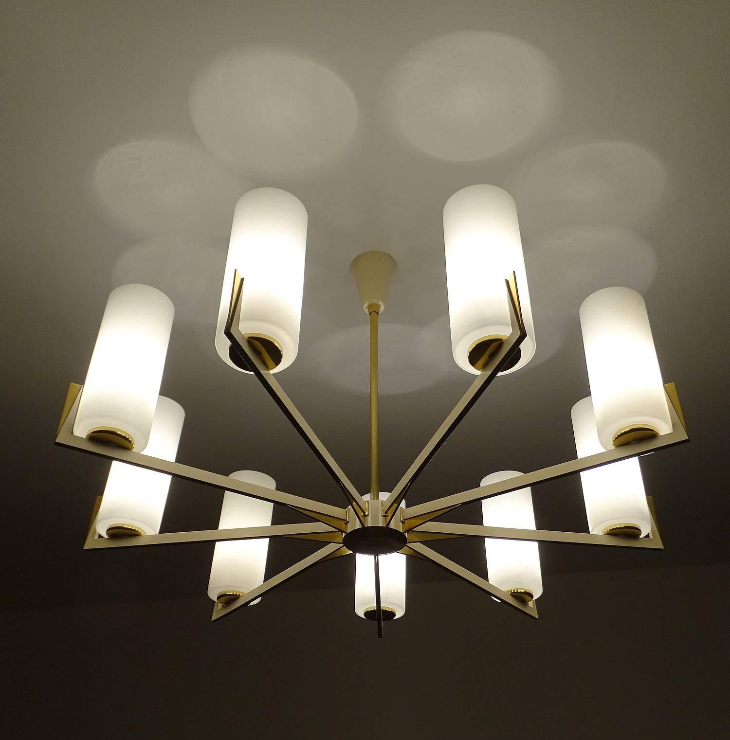 Very large sunburst chandelier in the manner of Arredoluce, 1950s , brass and cream white lacquered metal, finish, unusually large opaline glass diffusers. High end all brass quality.

Nine standard bulbs @ 60 watts each, - LED compatible - runs