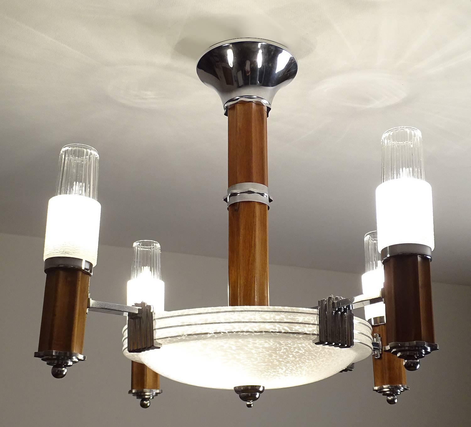 Spectacular large French Art Deco chandelier, circa 1935-1945, featuring a large glass shade with triple chrome banding highlight, flanked by four towers in skyscraper design in wood, chrome and glass (clear and opaque)
22.64 in.H / 57.5